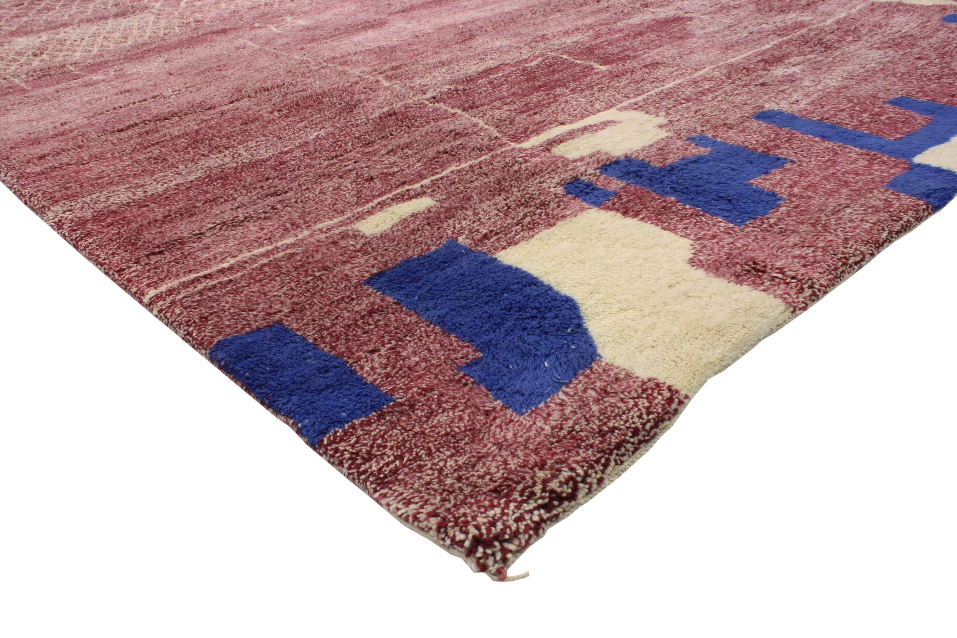 Boasting beautiful colors and impeccable weaving, this contemporary boho chic Moroccan style rug features Modern Tribal Design. Rendered in variegated shades of deep red, pink, cream and blue. The colors combined with the ancient Moroccan symbols