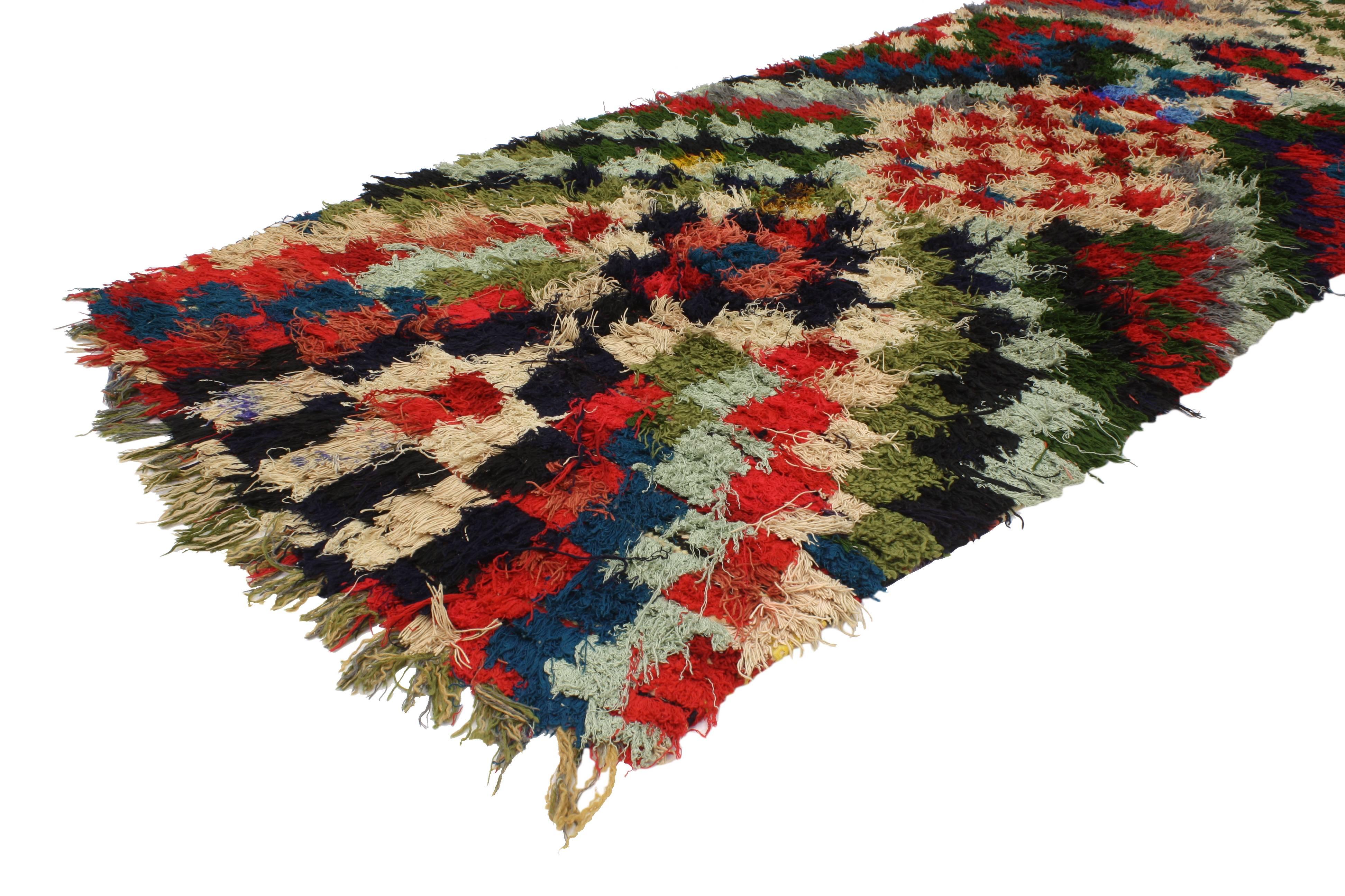 20381 Vintage Boucherouite Moroccan Runner, Colorful Moroccan Shag Hallway Runner. This Mid-Century Modern Moroccan runner features a checkerboard design woven in a striking combination of red, blue, black, green and cream. This vibrant and high