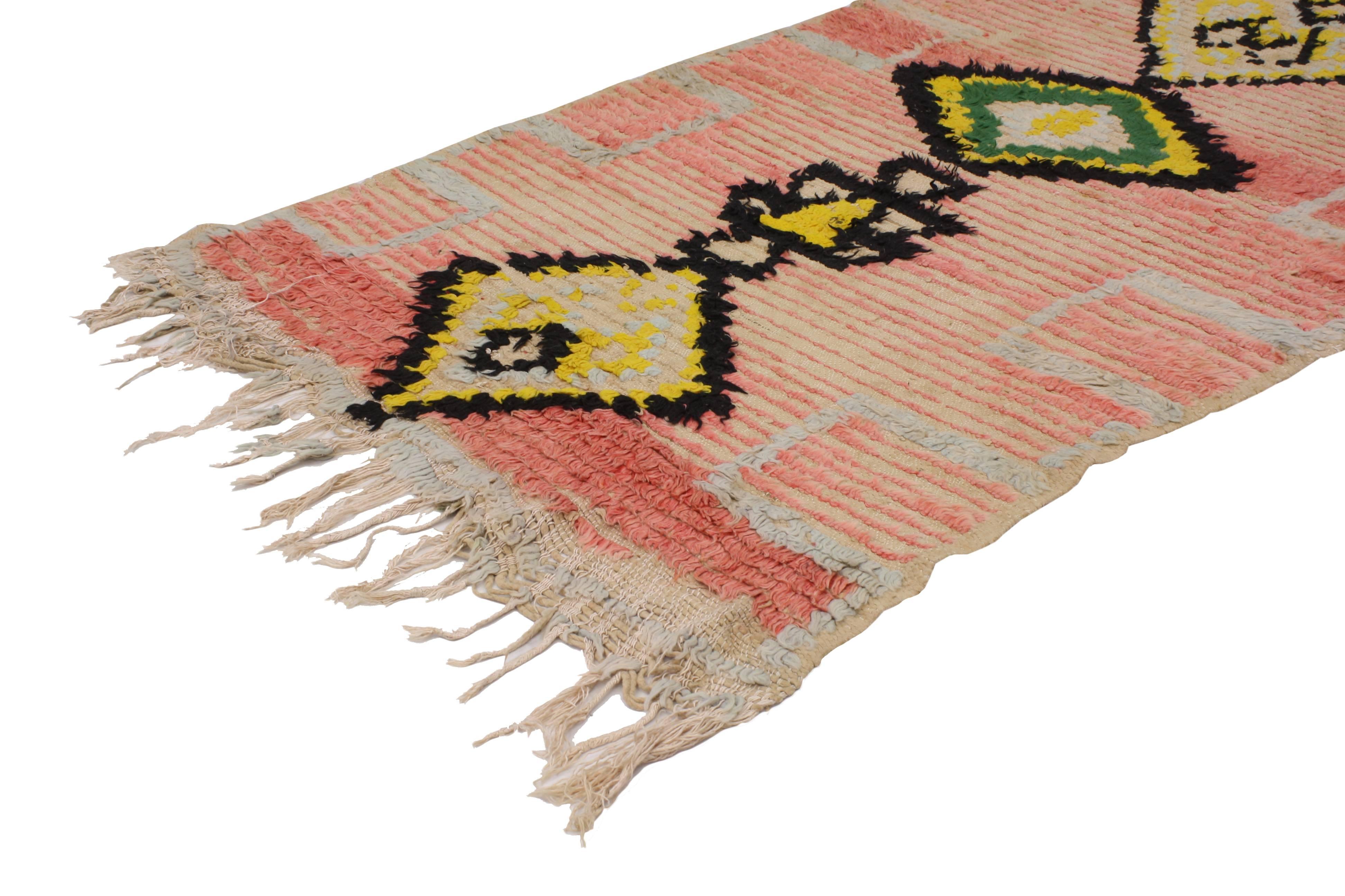 Causal and calm or subtle Bohemian, this vintage Berber Moroccan runner features a beautiful sun-faded composition. A series of ancient Berber symbols add intrigue to its modern tribal design aesthetic. Rendered in variegated shades of peach, pink,