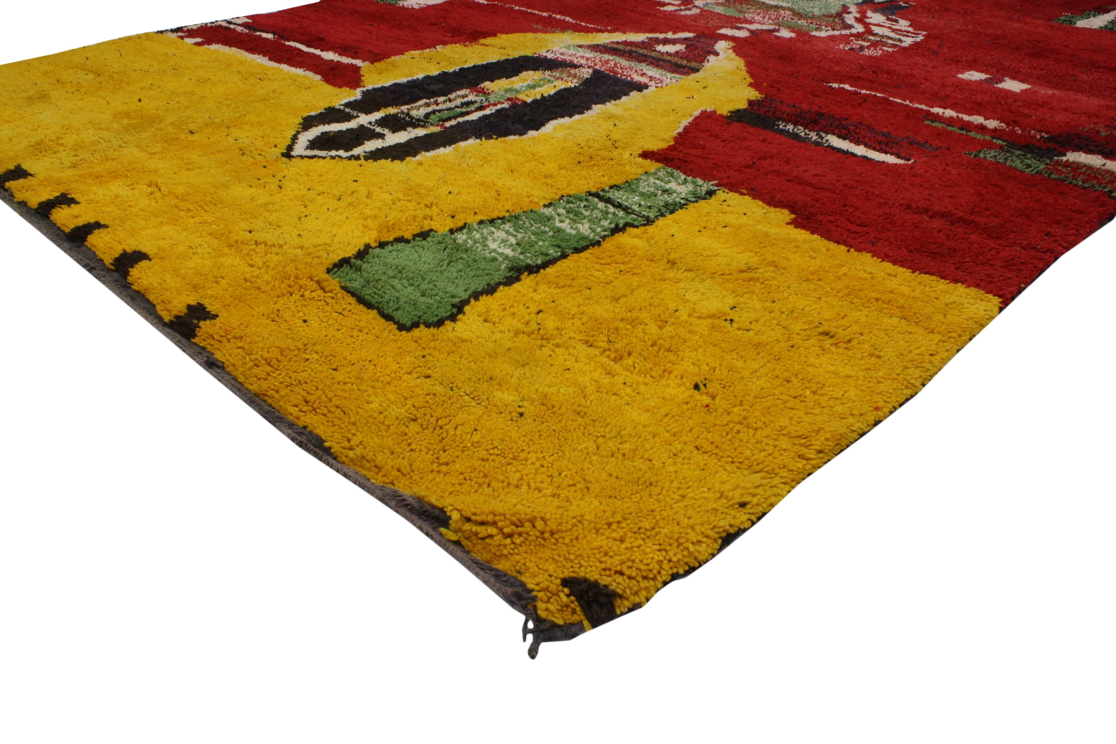 Contemporary abstract style with a tribal twist. This Berber Moroccan rug comes alive with its saturated red and yellow background, contrasting beautifully with the black, white and green tribal design. Freshen up your space and inject color with