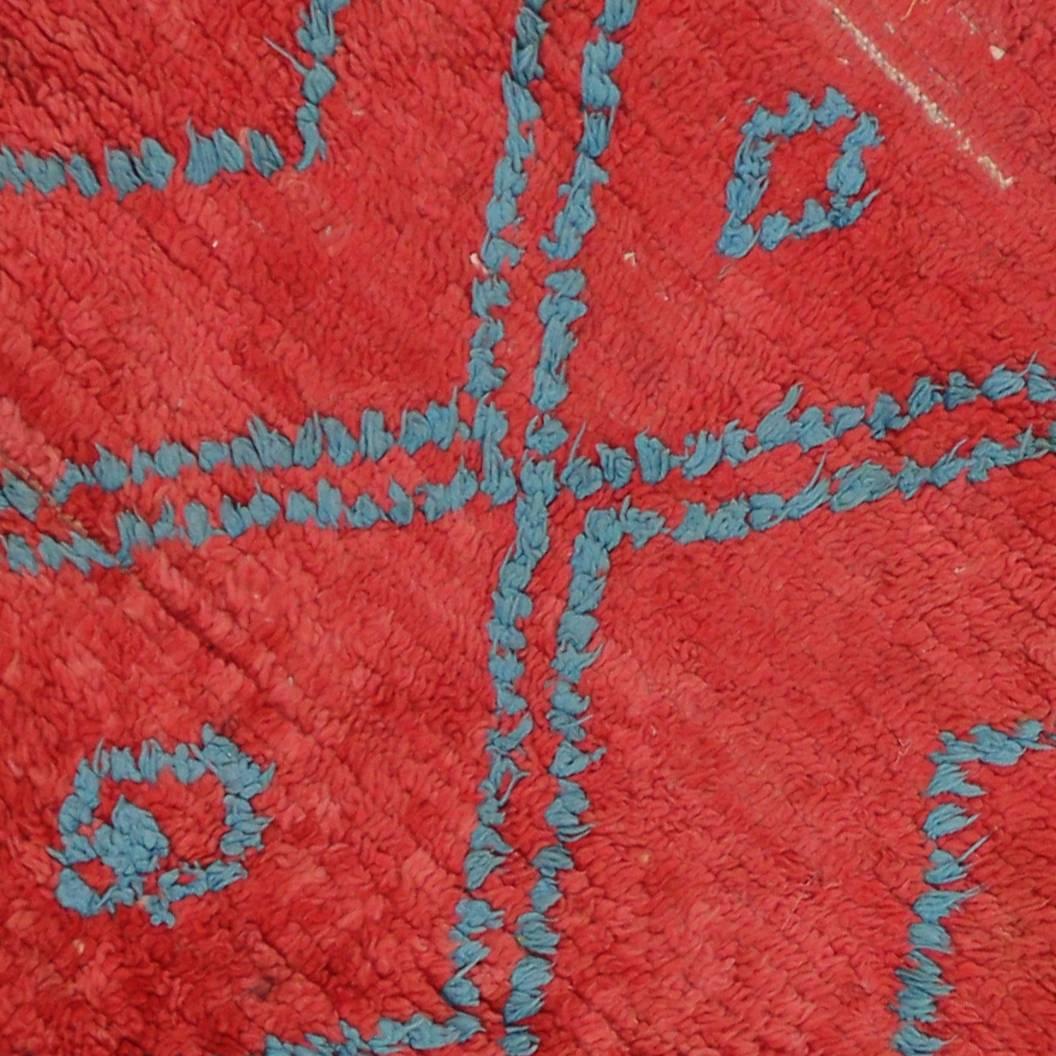 This vintage Berber Moroccan runner is characterized primarily by the ravishing red field and modern tribal design. The bold red field and contrasting blue lines serve as an interesting aesthetic function, complementing sensibly with boho chic