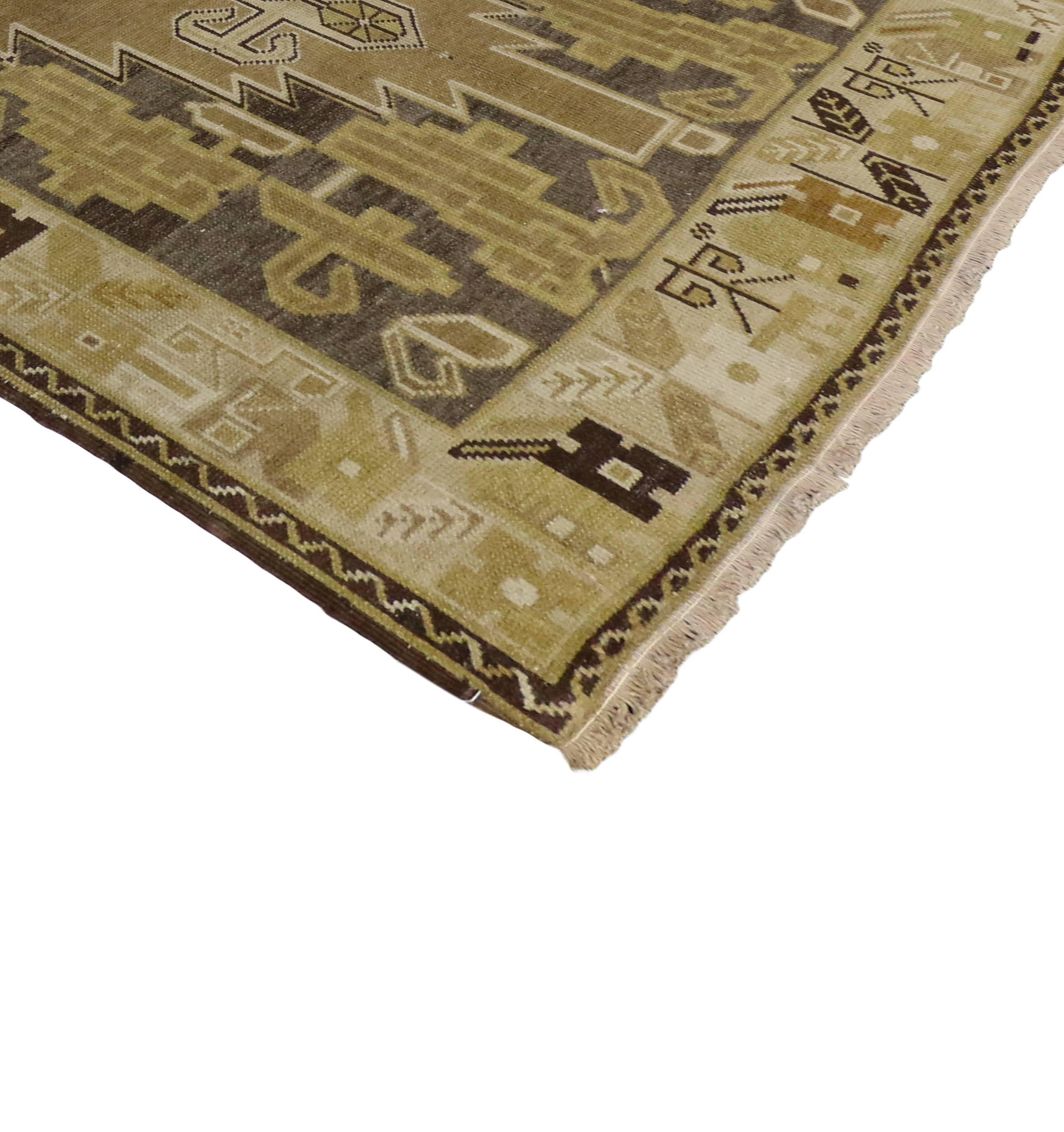 This vintage Turkish Oushak carpet runner with its Mid-Century Modern style bears a remarkable air of chic sophistication. Beautifully displayed, two large center medallions feature modern tribal motifs in an open abrashed of warm earth-tone colors.