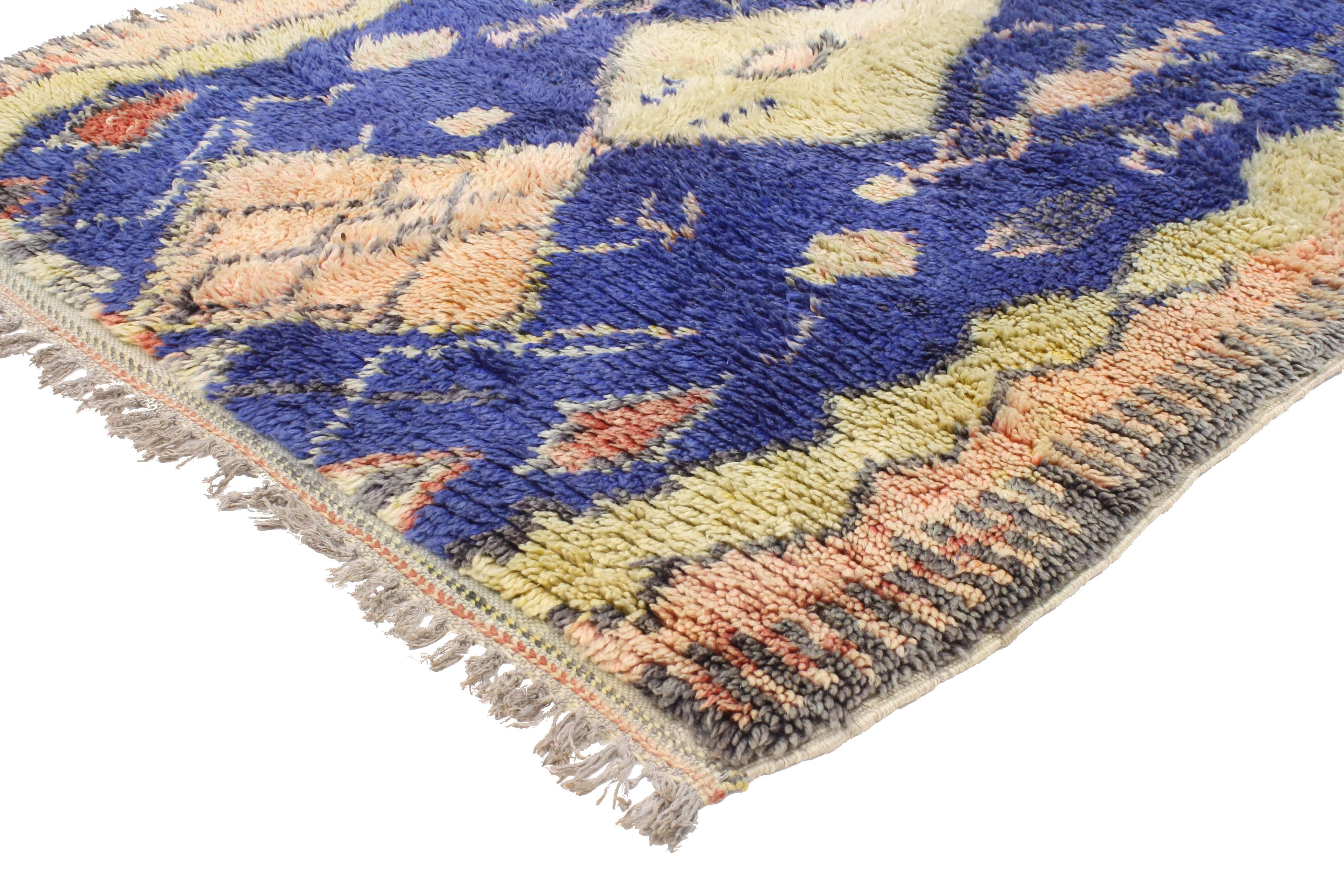 Infuse your space with this boho chic vintage Berber Moroccan rug with tribal design. Saturated in an extraordinary palette of blue, this Berber Moroccan rug is an excellent representation of Primitive charm. Rendered in blue, apricot-blush, gray