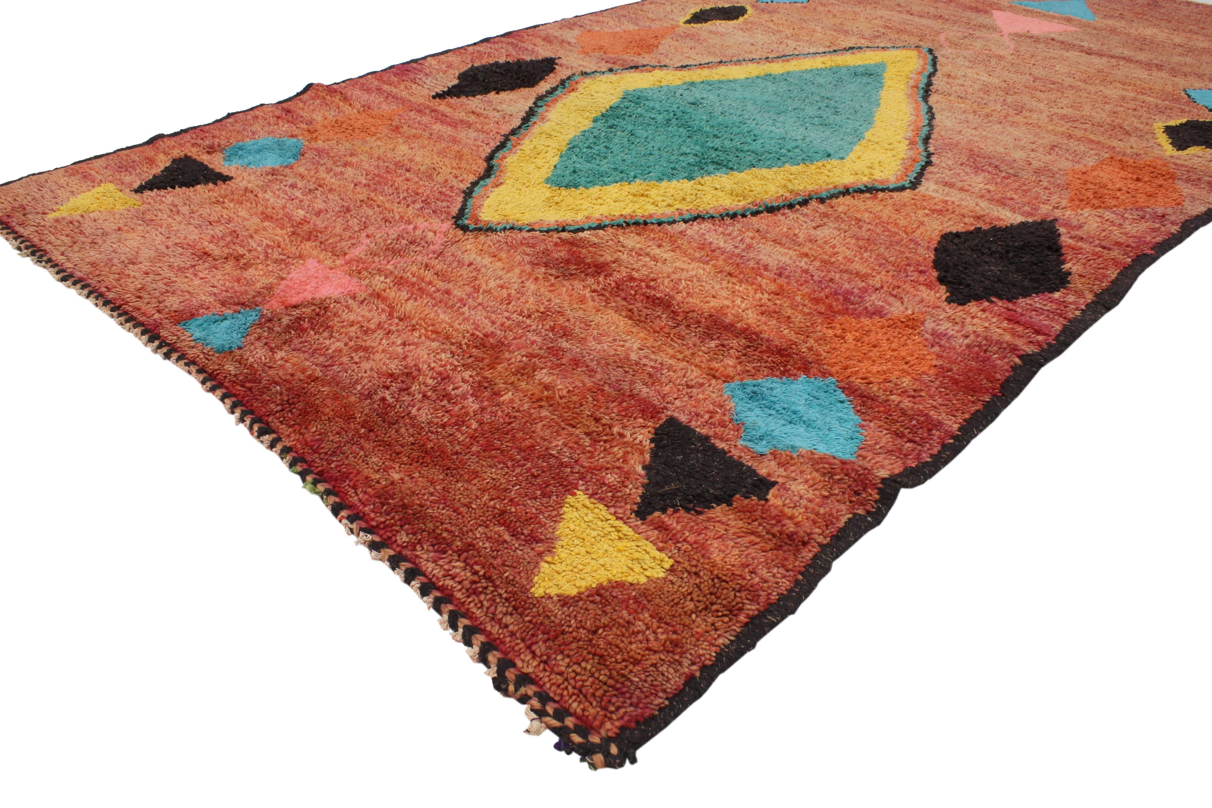 Impeccably woven from hand-knotted wool and displaying a modern tribal style, this vintage Berber Moroccan rug features a large diamond medallion surrounded by triangles, diamonds and other geometric motifs in an abrashed rustic red field. Blending