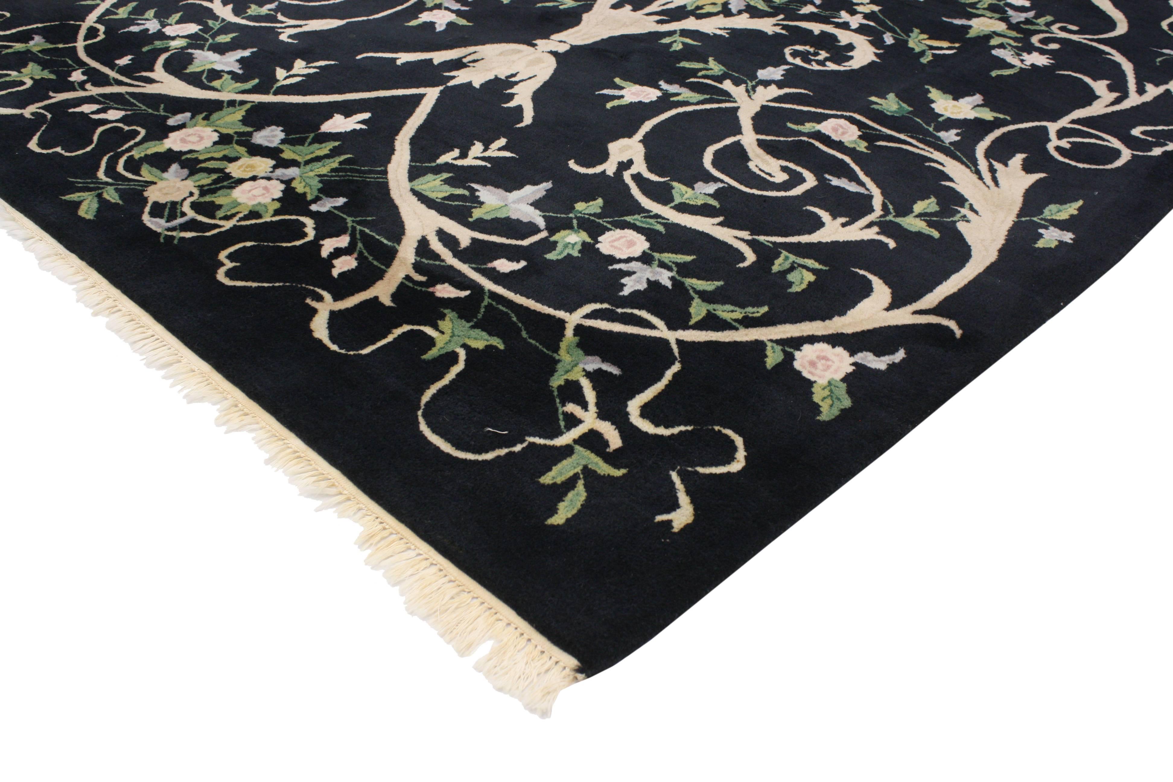 Questo tappeto indiano vintage presenta un campo nero e un moderno stile Aubusson. Il contrasto elevato e lo stile moderno e tradizionale completano un'ampia gamma di interni. Realizzato in nero, beige, azzurro, verde, rosa, grigio e giallo oro