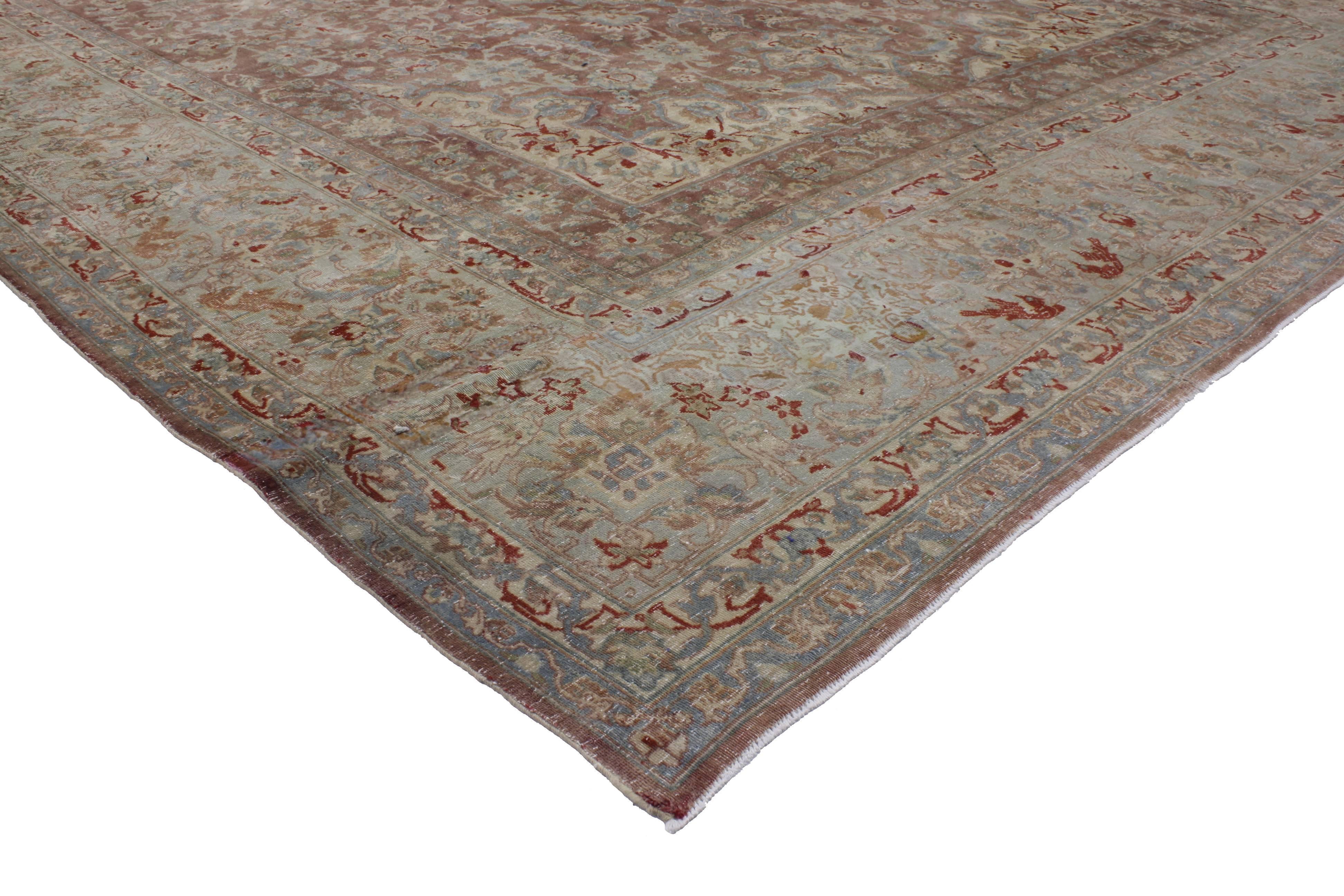 51796 Distressed Antique Persian Kerman Rug, Industrial Style Kirman Area Rug. This charming vintage Kerman (Kirman) rug features an all-over grand scale floral pattern with delicately colored botanical motifs and sweeping vines Meander across the