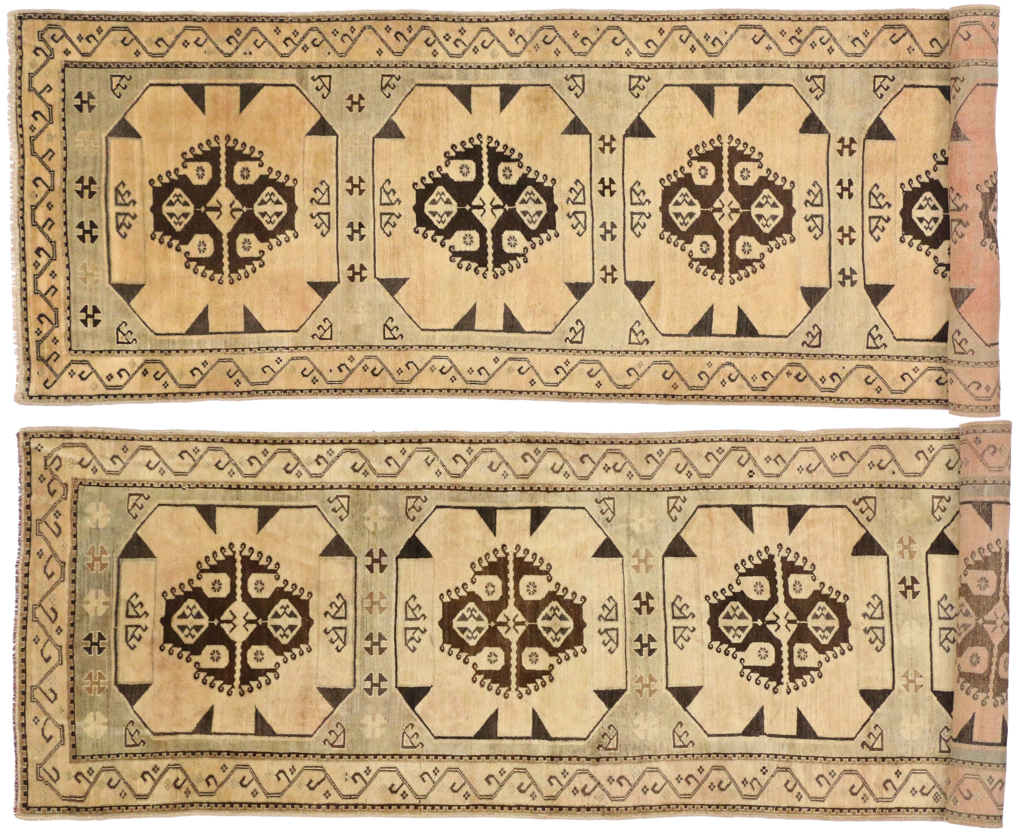 This amazing pair of vintage Turkish Oushak carpet runners from the Provincial weaving centre of Ushak features simplistic medallions with a modern style and muted colors. The modest field tastefully blends into the Minimalist and muted background.