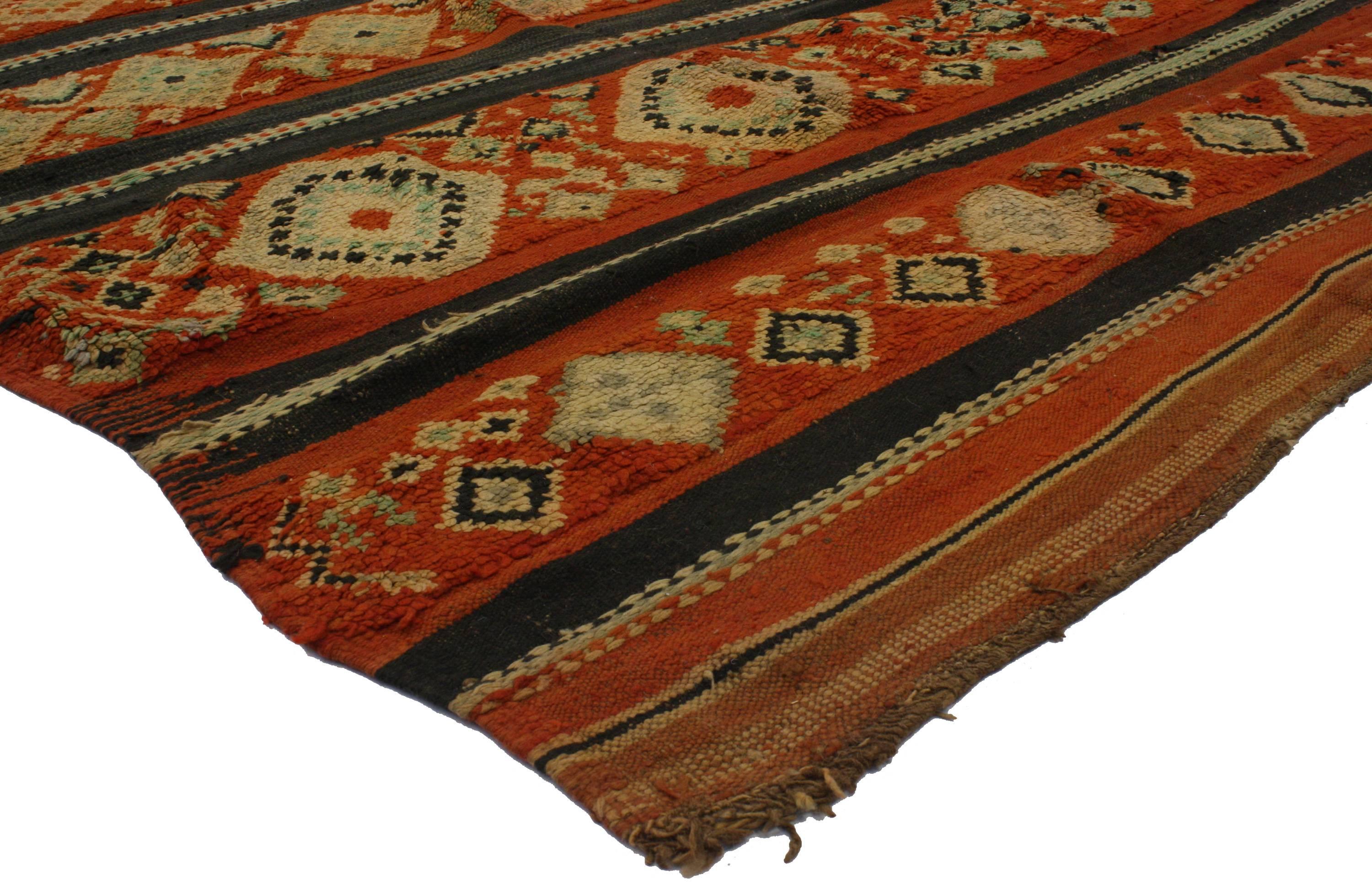 Saturated with good taste and Primitive charm, this vintage Berber Moroccan rug features modern tribal style. It is swathed in variegated shades of rust, orange-red, hot pink, orange, rust, mint green, lavender, beige, brown and black. Give your