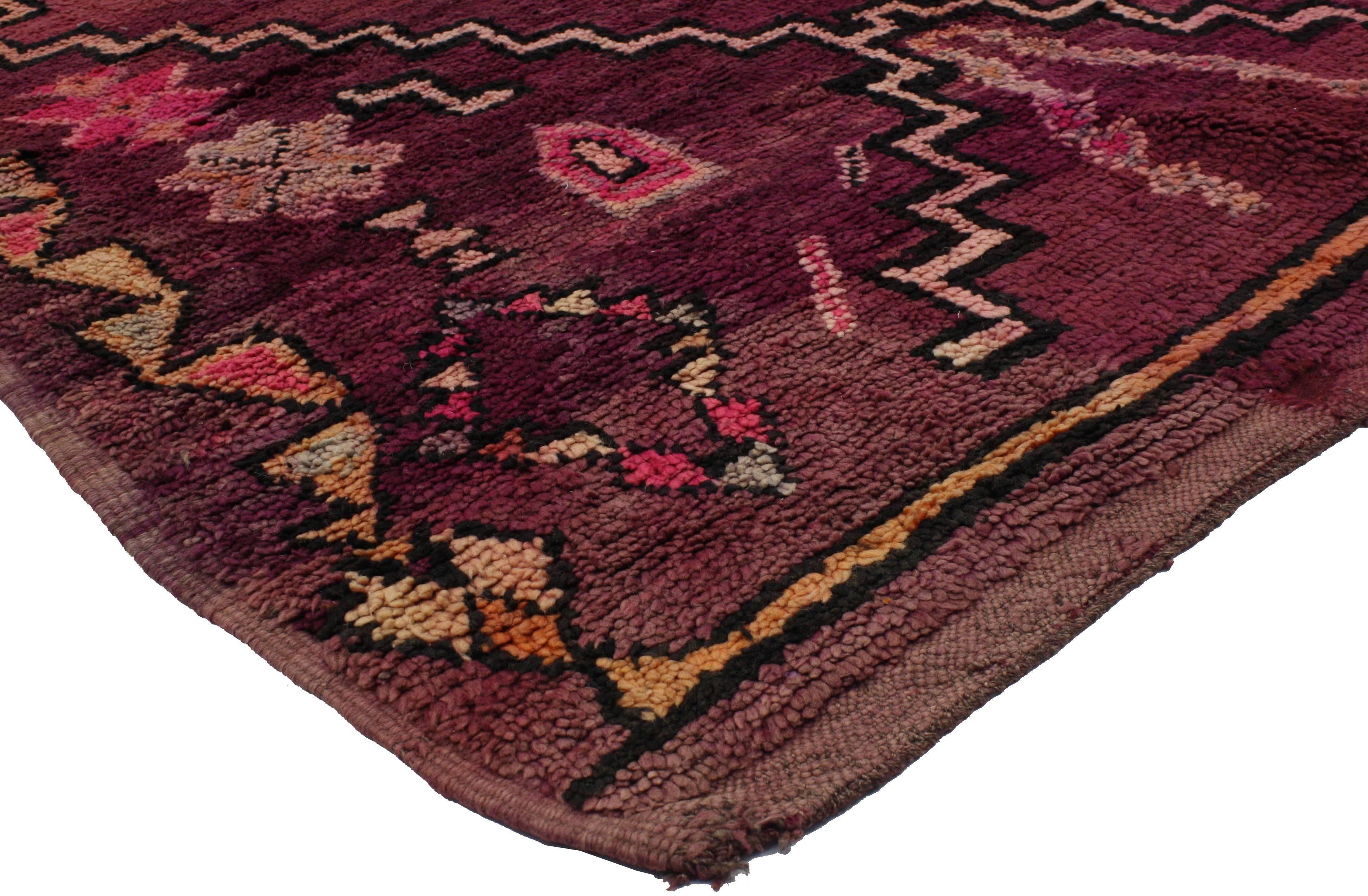 Saturated with good taste and modern tribal style, this vintage Berber Moroccan rug swathed in variegated shades of raspberry, burgundy, maroon, wine, oxblood red, hot pink, plum, purple, lavender, orange, gray, black, brown and beige. Everything