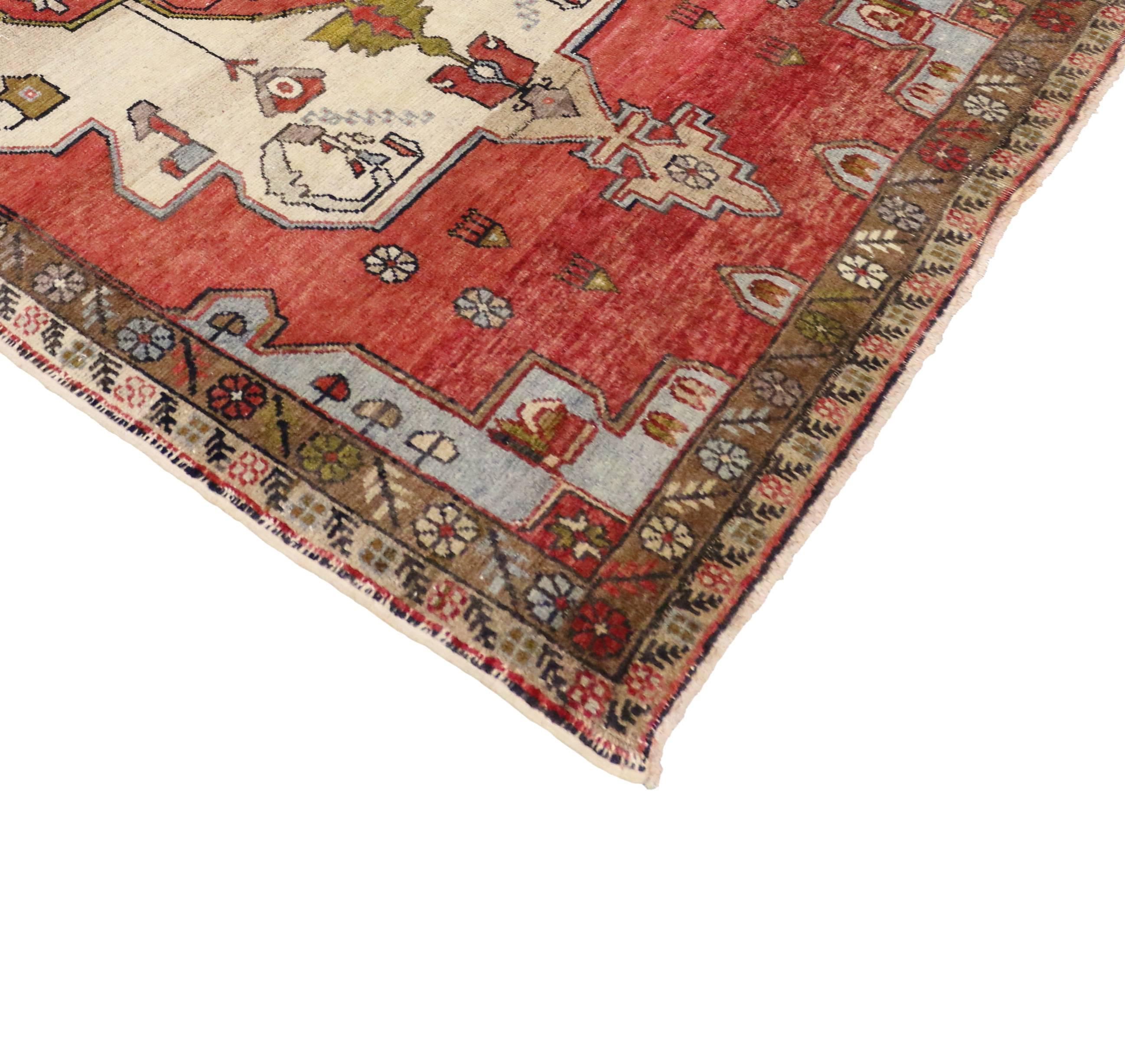 Hand-knotted wool vintage Turkish Oushak gallery rug featuring a red centre medallion in an open ivory and red field with rich waves of abrash. Rendered in a refined palette of vibrant colors: red, ivory, green, slate blue, gray, brown and beige.
