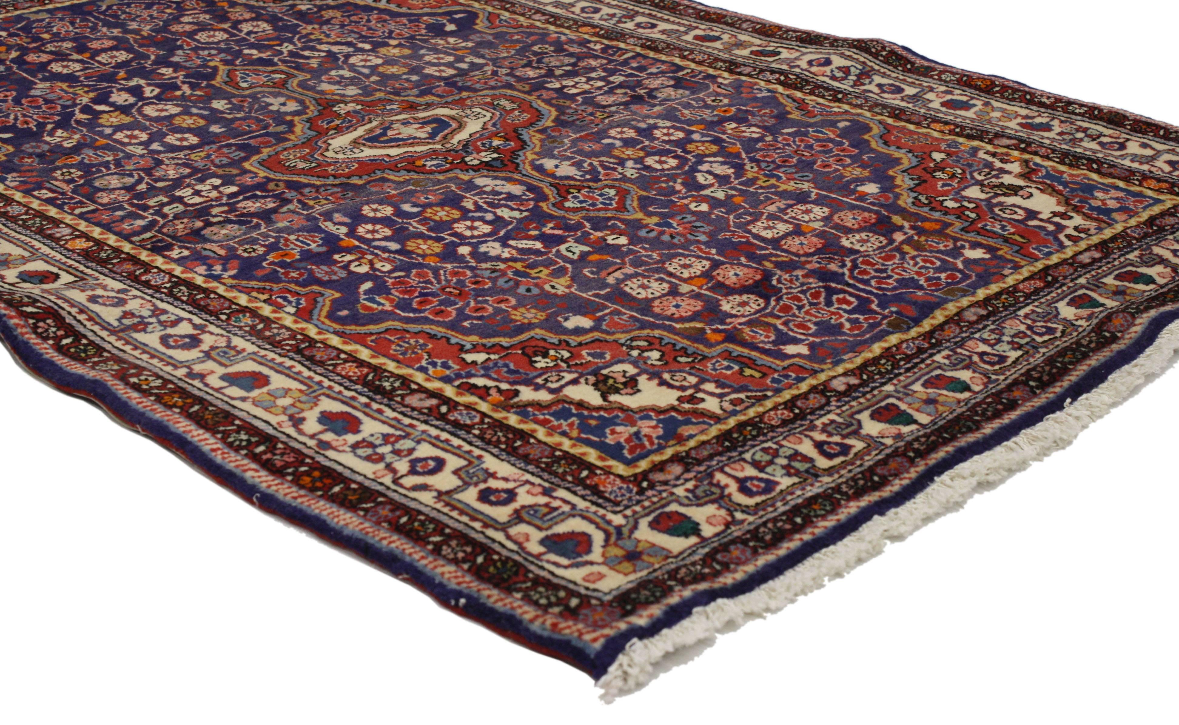 Dieser alte persische Sarouk-Teppich im traditionellen Stil zeigt ein kompliziertes Mittelmedaillon mit zwei Kartuschen in einem blauen Feld, das von einem geometrischen Muster umgeben ist. Ein zeitloses Design kombiniert mit einer raffinierten
