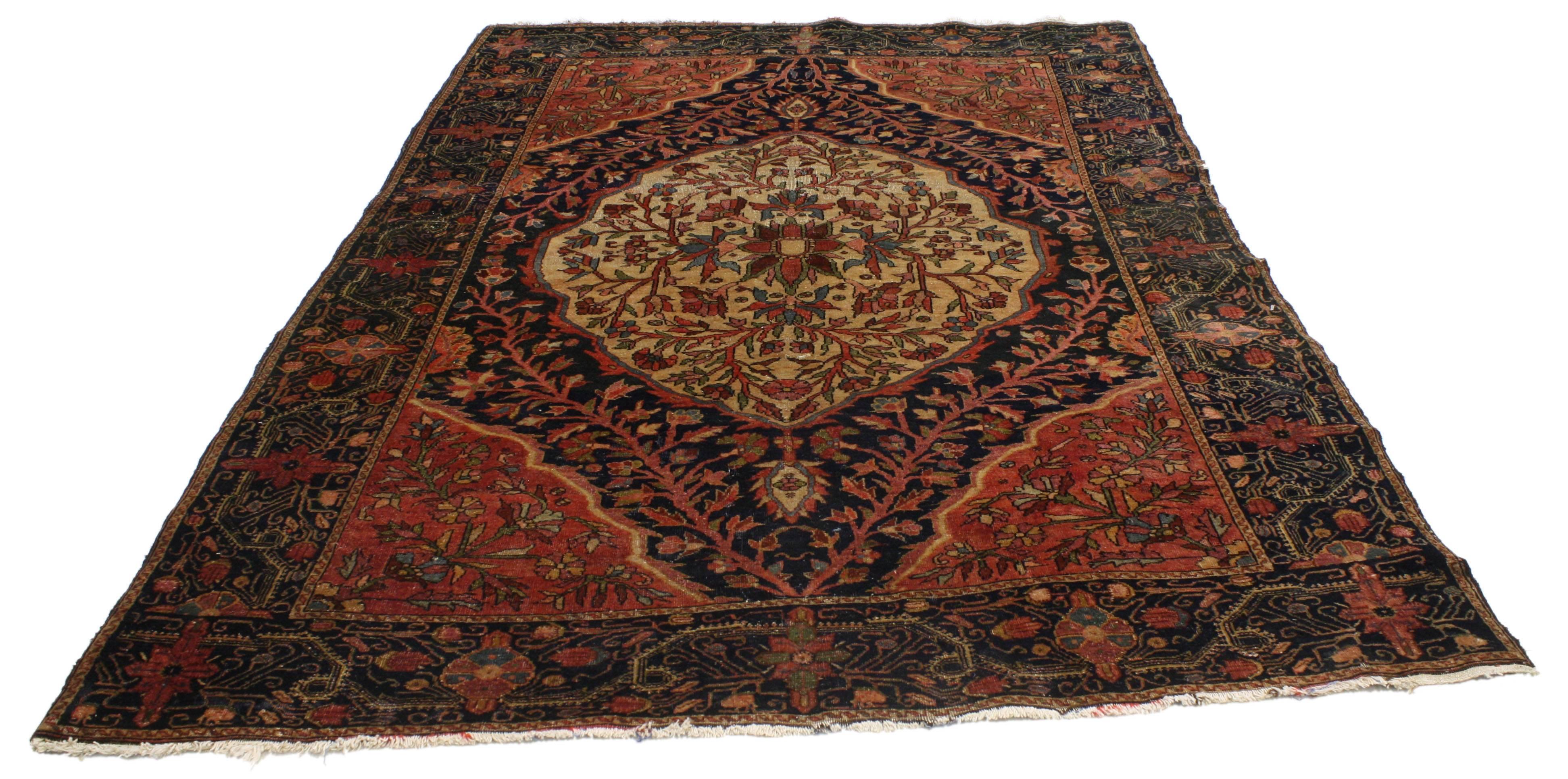 This highly desirable antique Persian Farahan rug with modern traditional style features an intricate center medallion in a navy blue field surrounded by red quarter panels. Rendered in a refined palette illuminating the lively, composition of this