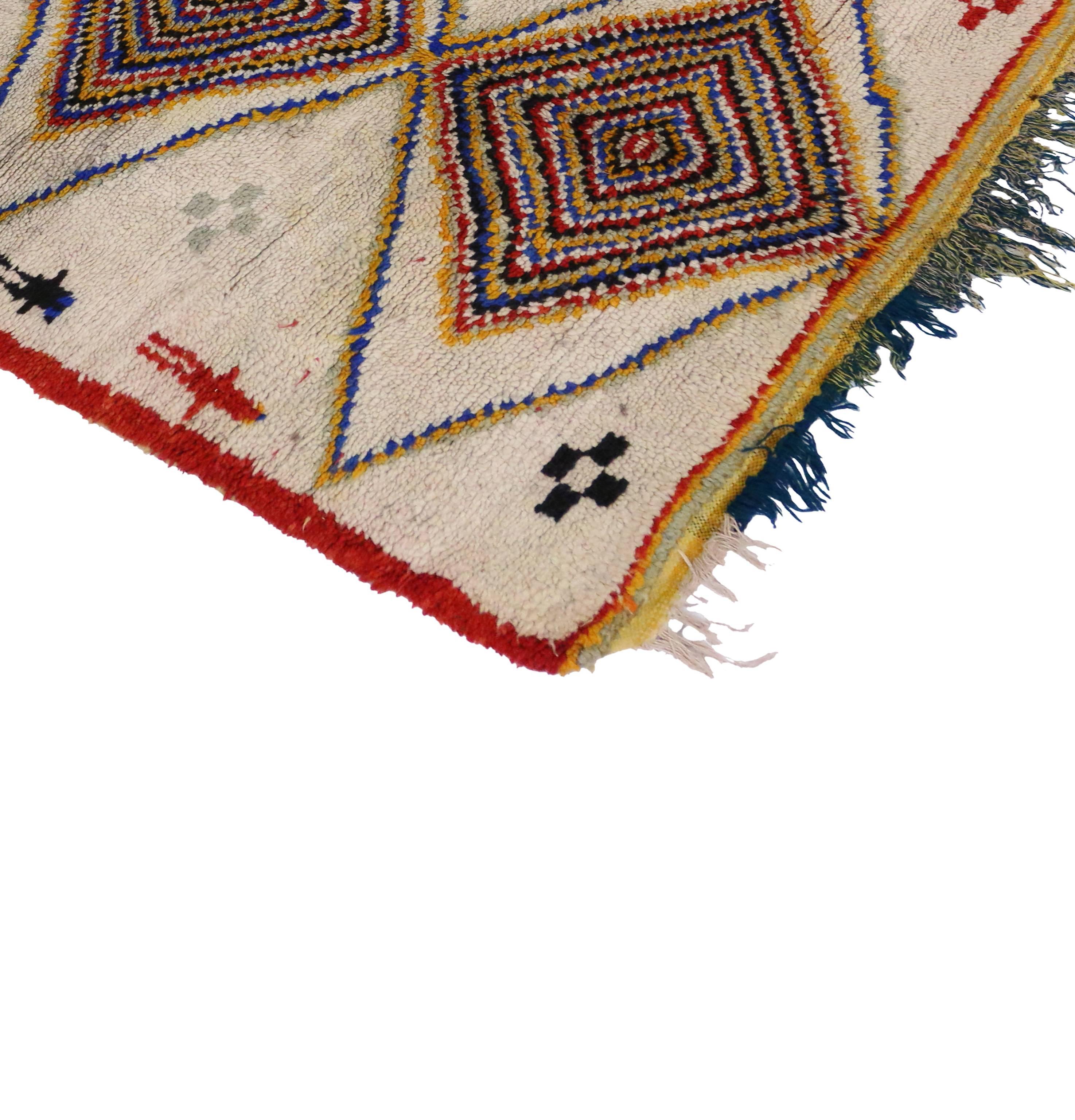 Joining the graphic appeal and folk-art warmth of Moroccan tribal motifs with energetic colors, this vintage Moroccan rug blends well with modernist decor and will add much needed color to a monochromatic interior. Believed to protect the human
