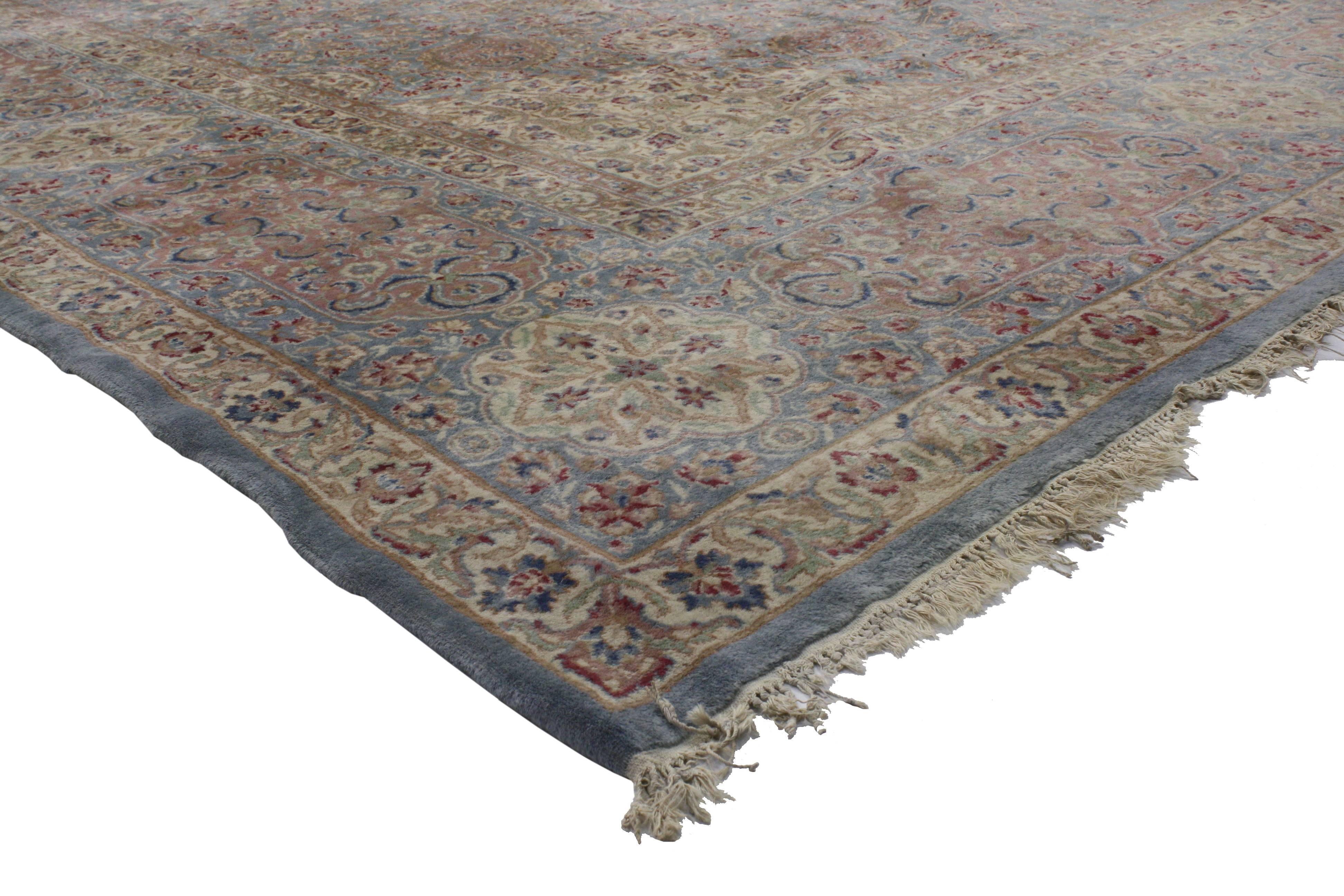 76599 Vintage Persian Kerman Rug 13'09 x 23'02.
This hand knotted wool vintage Persian Kerman rug features a sixteen point cusped medallion flanked by a ring of sixteen pointed ovals surrounded by an all-over floral pattern composed of blooming