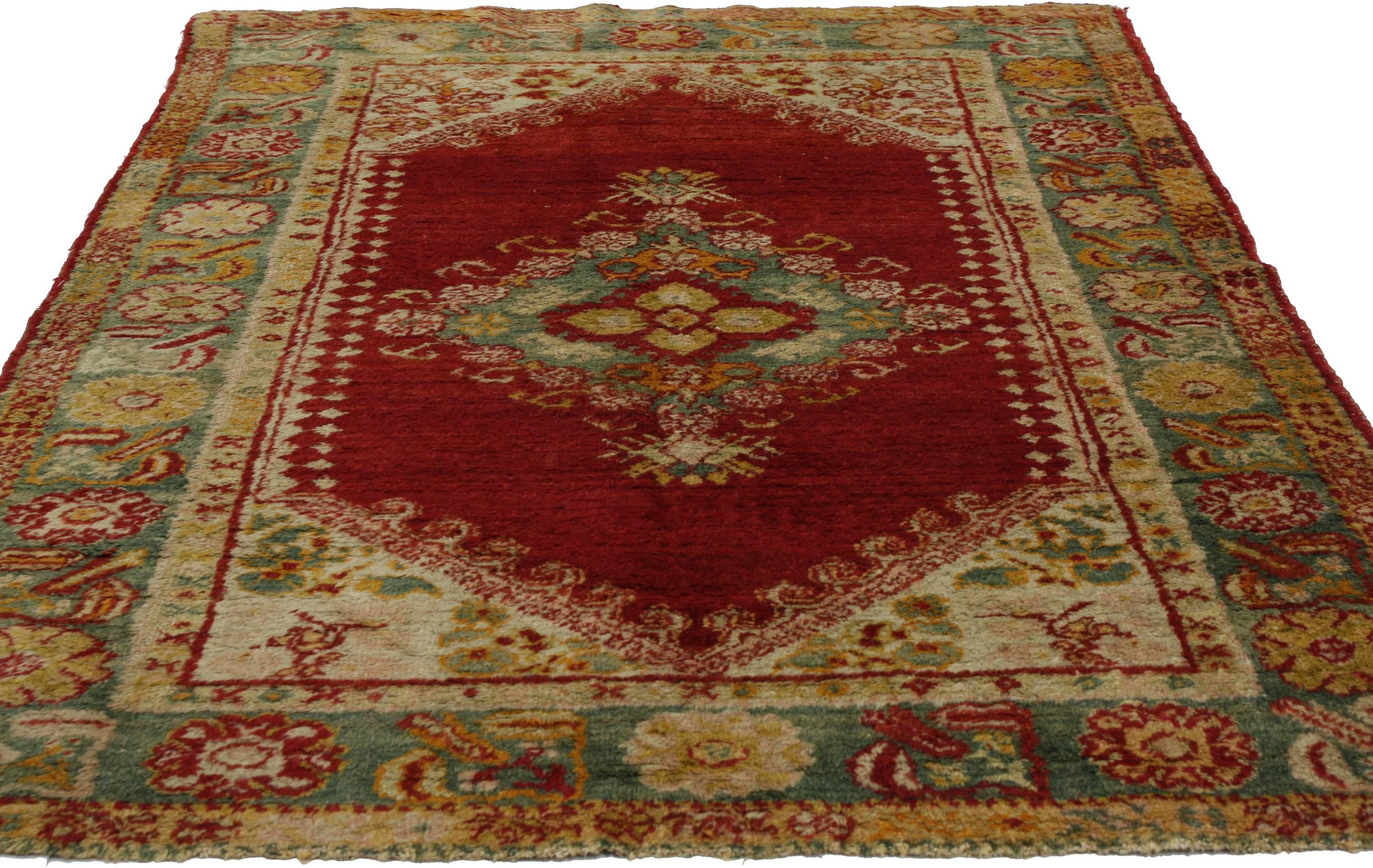 Ce tapis Oushak ancien comporte de nombreuses couches qui se complètent bien, avec une énergie symphonique qui captive l'attention immédiate. Une grande bordure sarcelle et de délicates fleurs entourent les éléments de conception colorés et