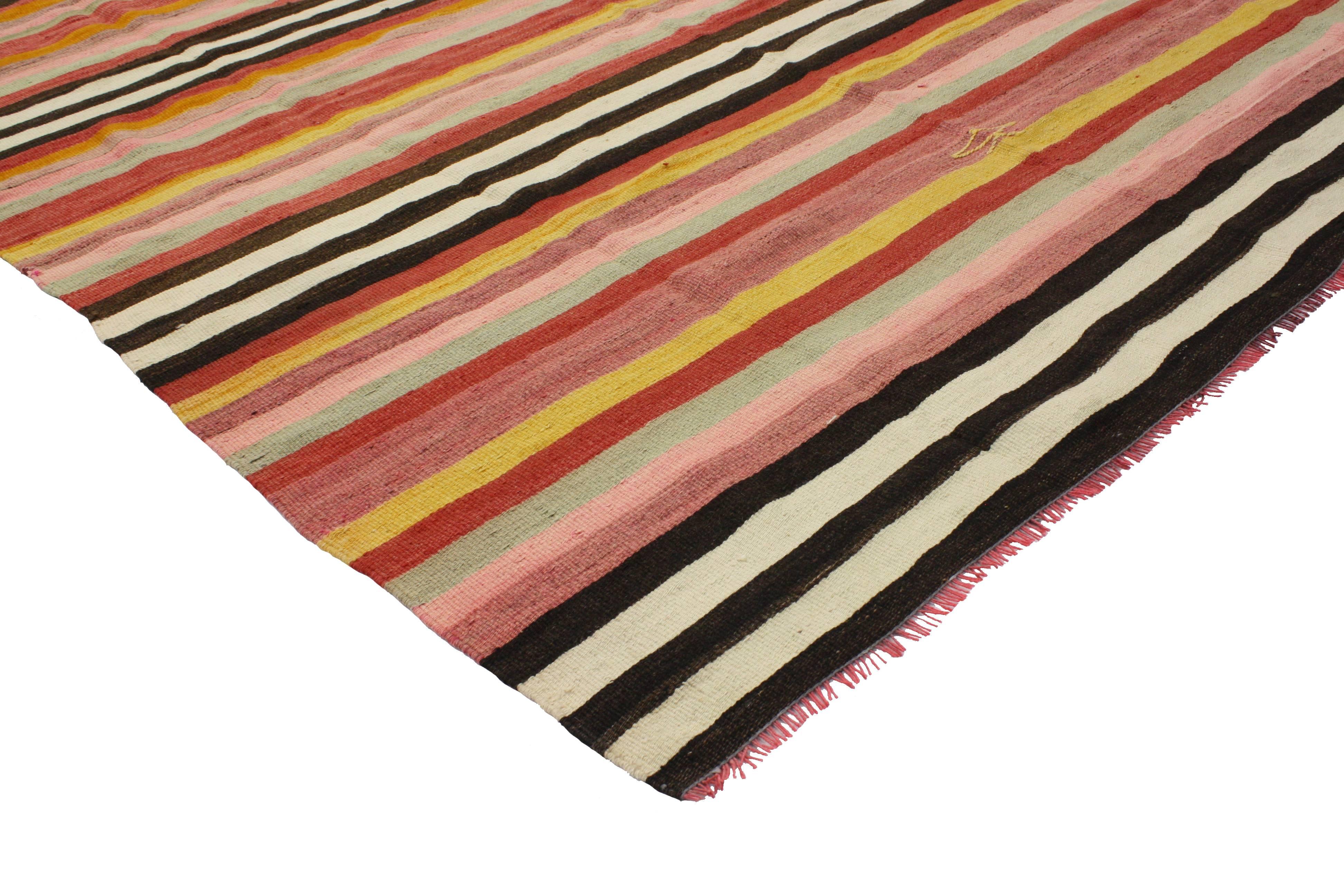Boasting lively colors and impeccable weaving, this vintage Turkish Kilim rug with stripes features a Boho Chic style. A fine example of simplicity and universal appeal, this vintage Kilim rug embodies the modern concept of less is more. Rendered