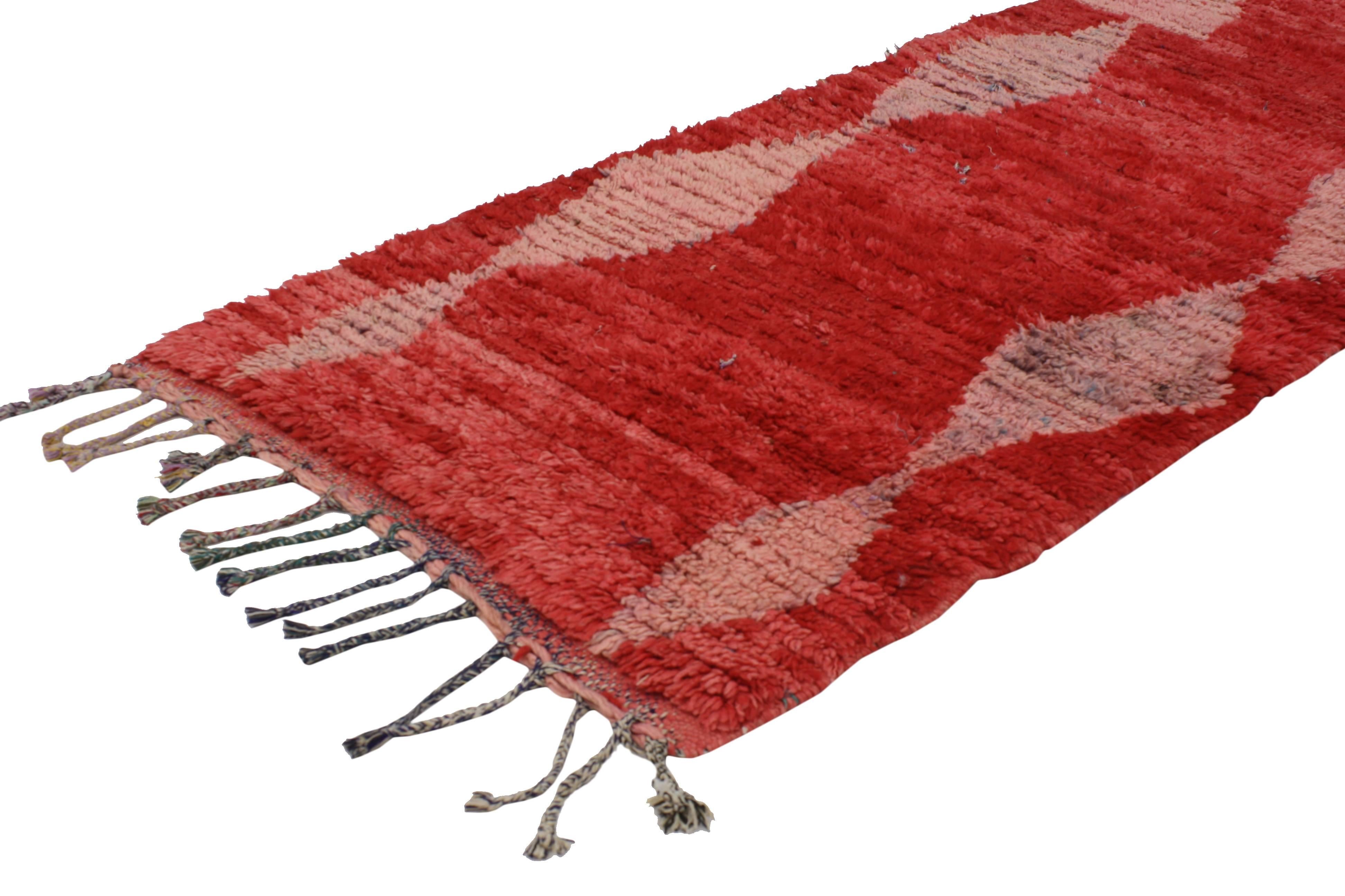 With the dramatic red color and Mid-Century Modern style, this vintage Berber Moroccan rug is not for the timid. Rendered in red, pink, beige, baby blue and lavender. Features two rows of stacked diamonds along the vertical side. The all-over