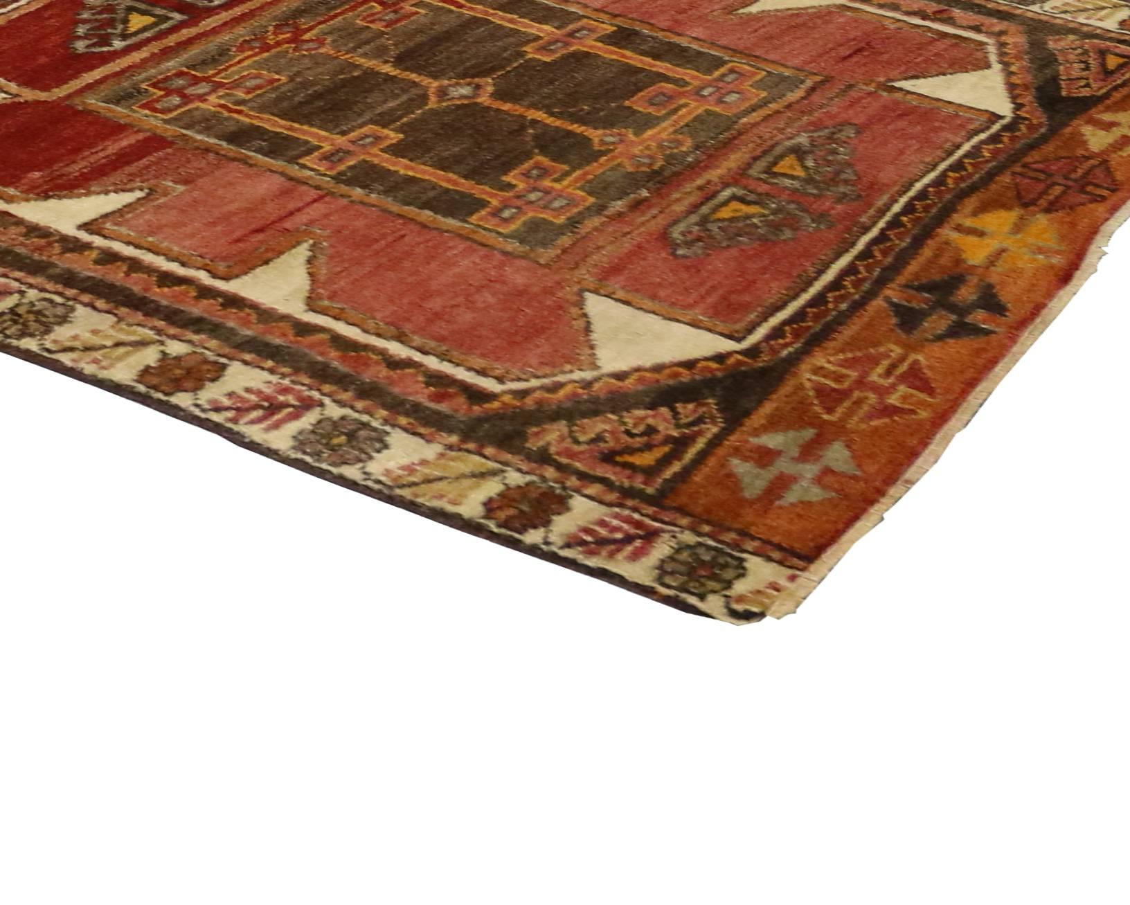 Hand-knotted wool vintage Turkish Oushak runner with Modern style featuring four large stacked hexagon medallions and tribal motifs with rich waves of abrash. Rendered in a refined palette of warm colors: espresso brown, red, chocolate brown, rust,