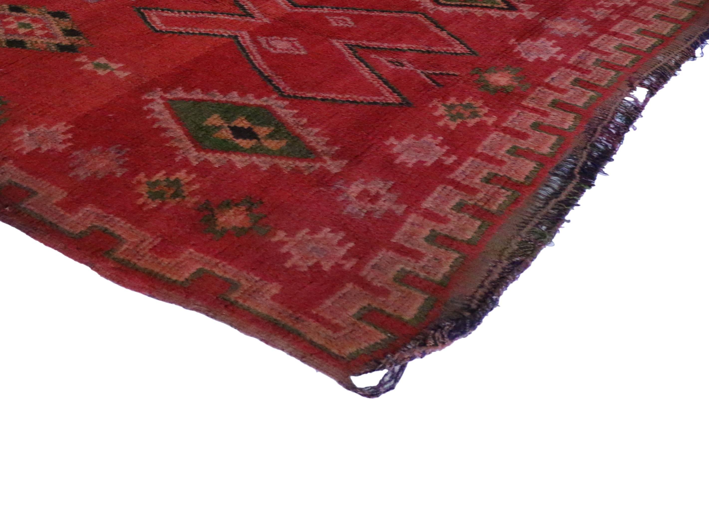 Saturated with good taste and a lively attitude, this vintage Berber Moroccan rug features modern tribal design. It is swathed in variegated shades of red, lavender, green, pink, beige, brown and black. Give your space a burst of sweet energy with