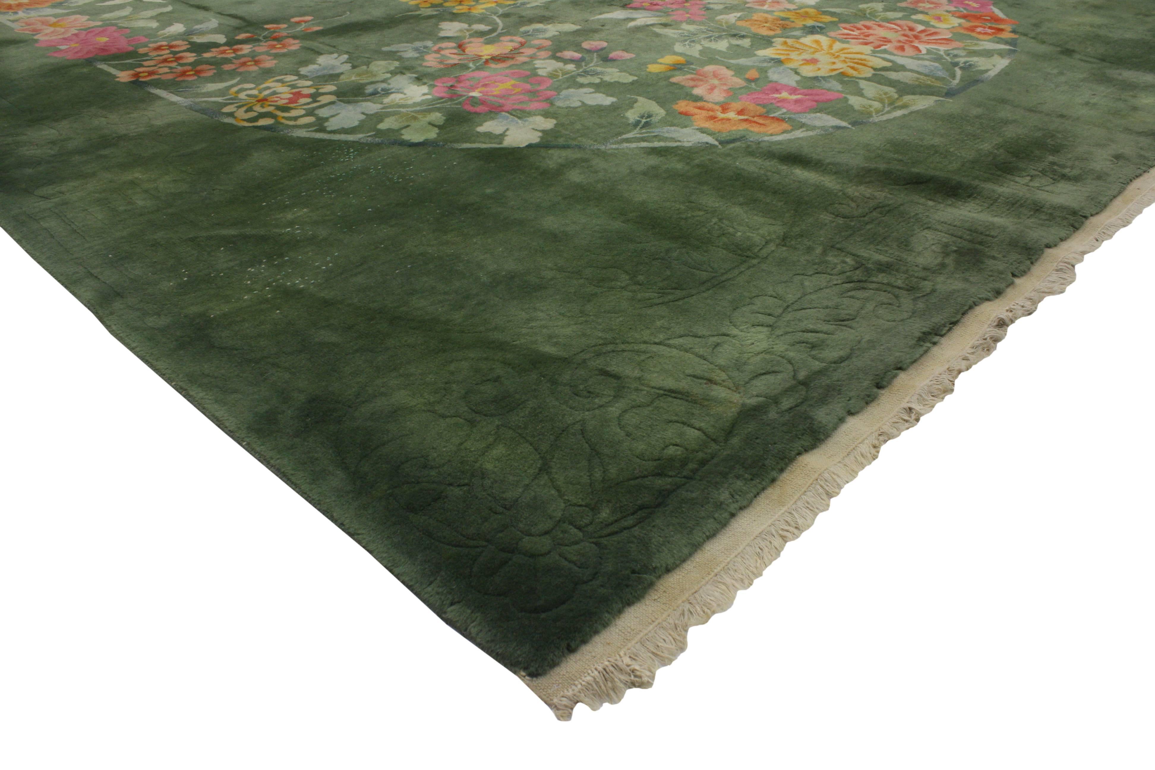 74995 Early 20th Century Antique Chinese Green Art Deco Rug with Traditional Chinoiserie Style 09'09 X 13'02. This hand knotted wool antique Chinese Art Deco rug features an abrashed green hued field festooned with an oval wreath of elegant sprays