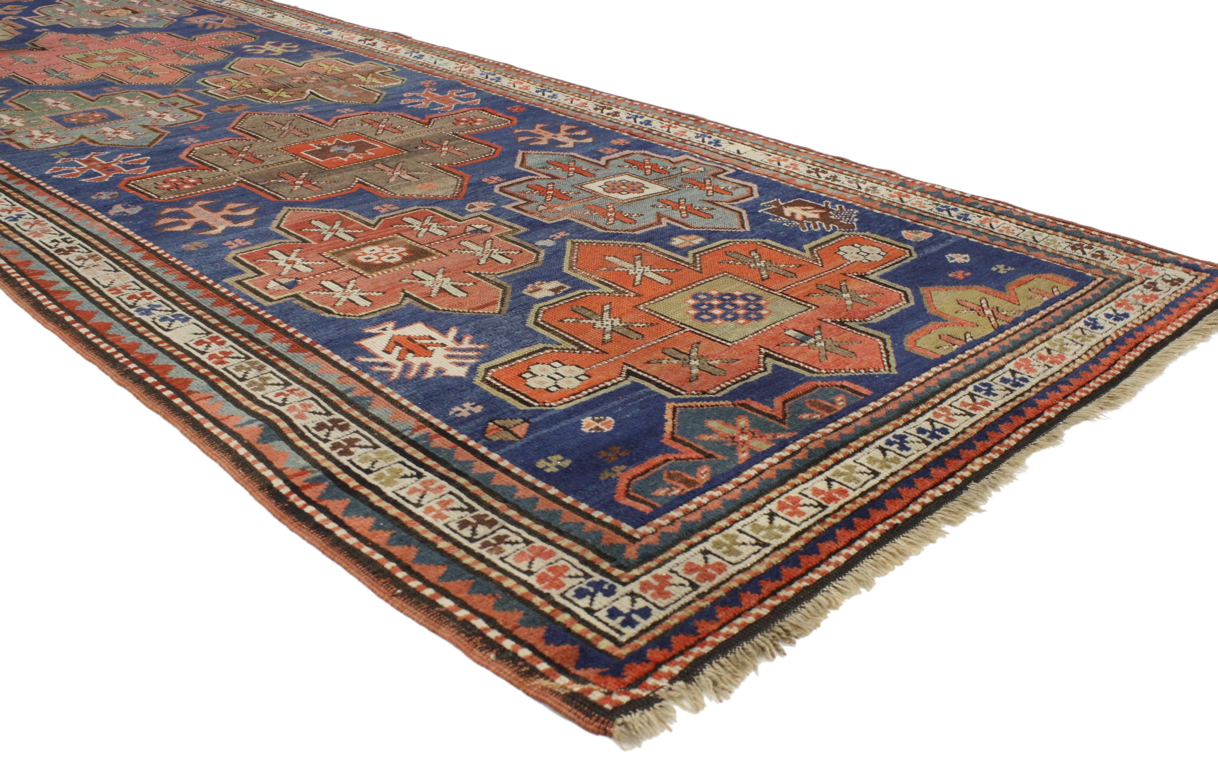 This antique Russian Kazak gallery rug with modern tribal style communicates some of the finer and more important points of geometric design elements. Classically composed and displaying rich waves of abrash, this antique Kazak rug features large