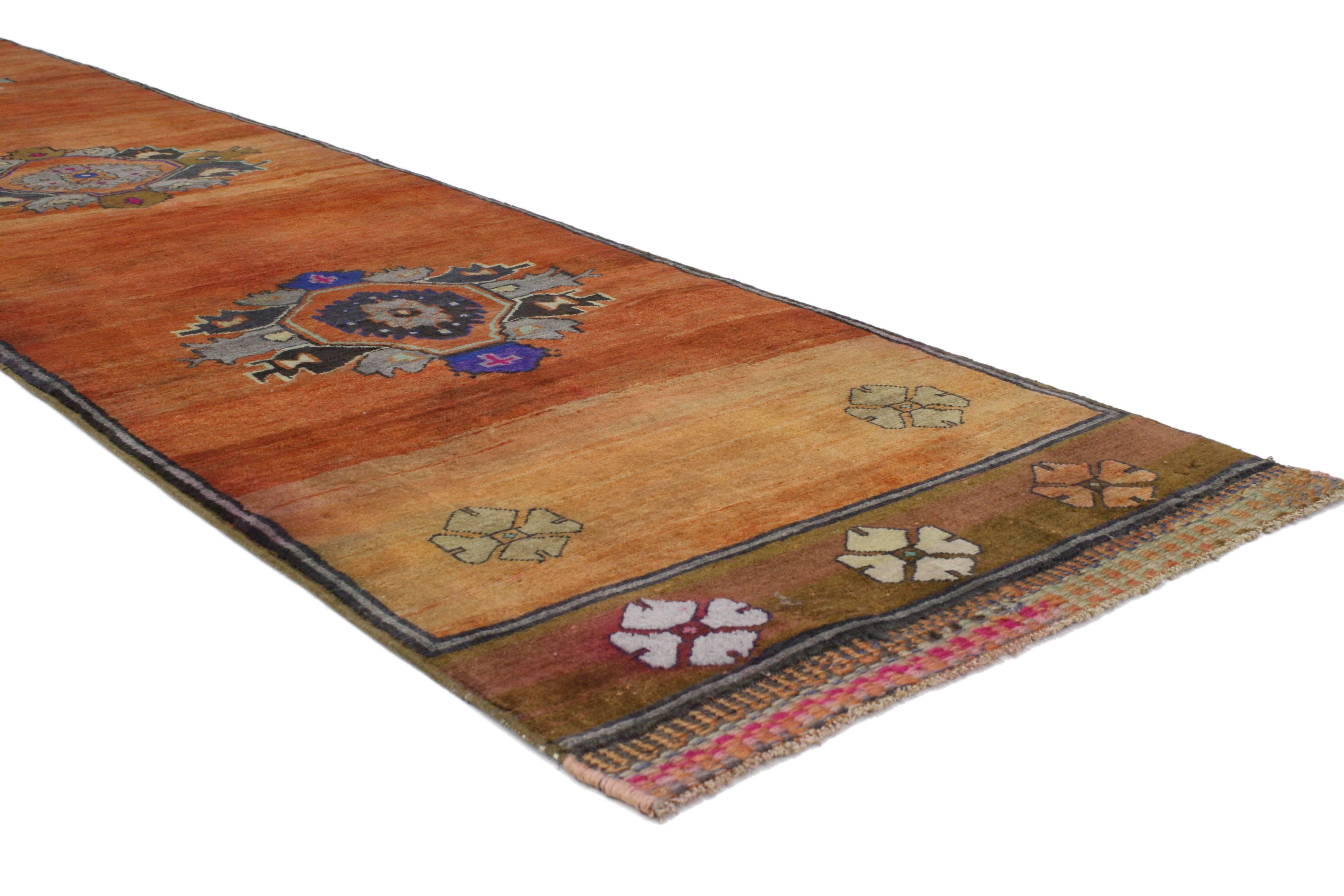 This vintage Turkish Oushak carpet runner with modern style displays rich waves of abrash throughout the composition. Immersed in Anatolian history and Mid-Century Modern style, this vintage Oushak runner nicely displays three medallions surrounded