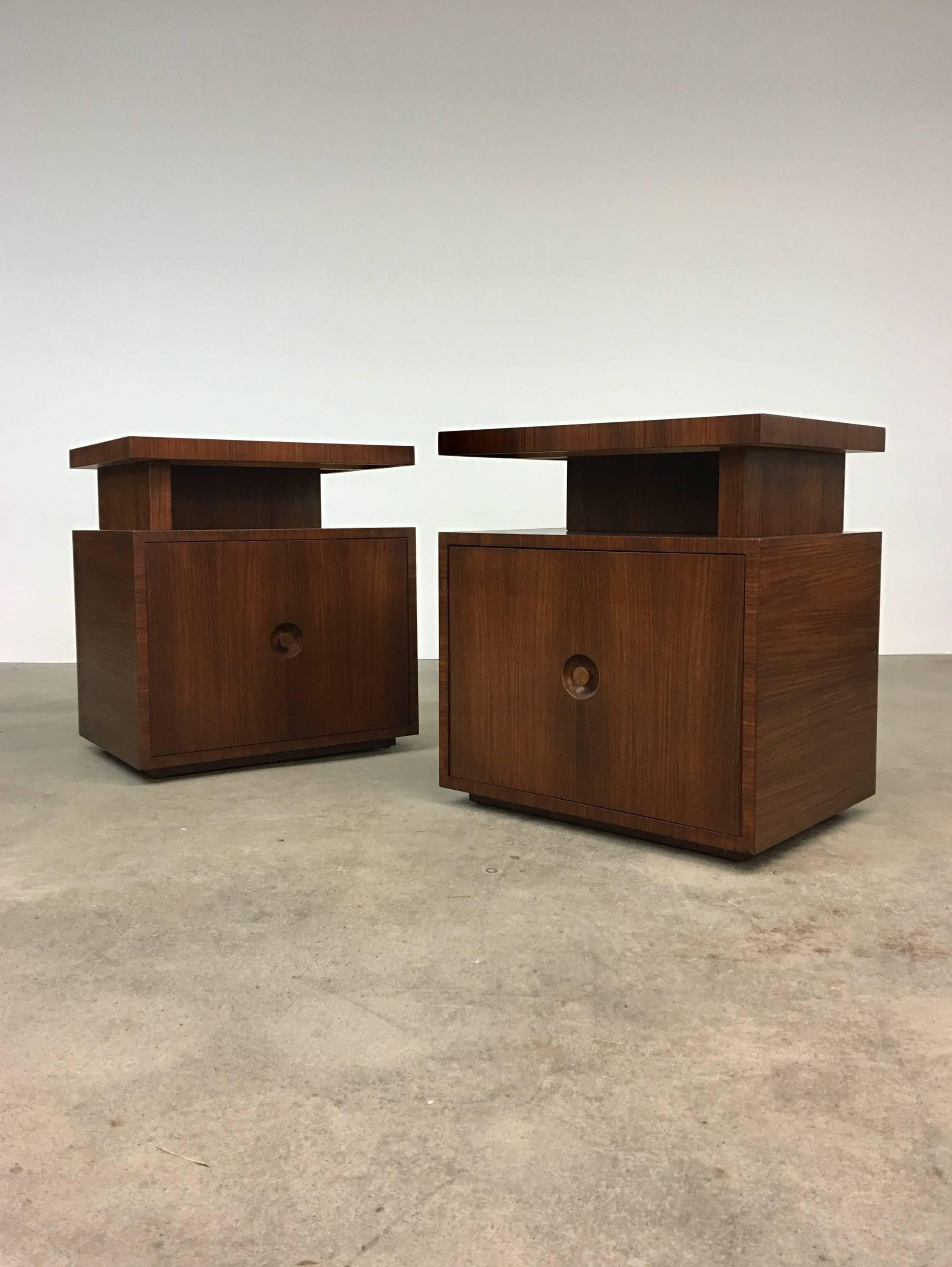 Pair of Andrew Szoeke end tables with floating tops in quarter-sawn rosewood, circa 1948. Single door with recessed, circular walnut knob opens to reveal an adjustable shelf. Fully signed with the Szoeke brass medallion. Could also be used as