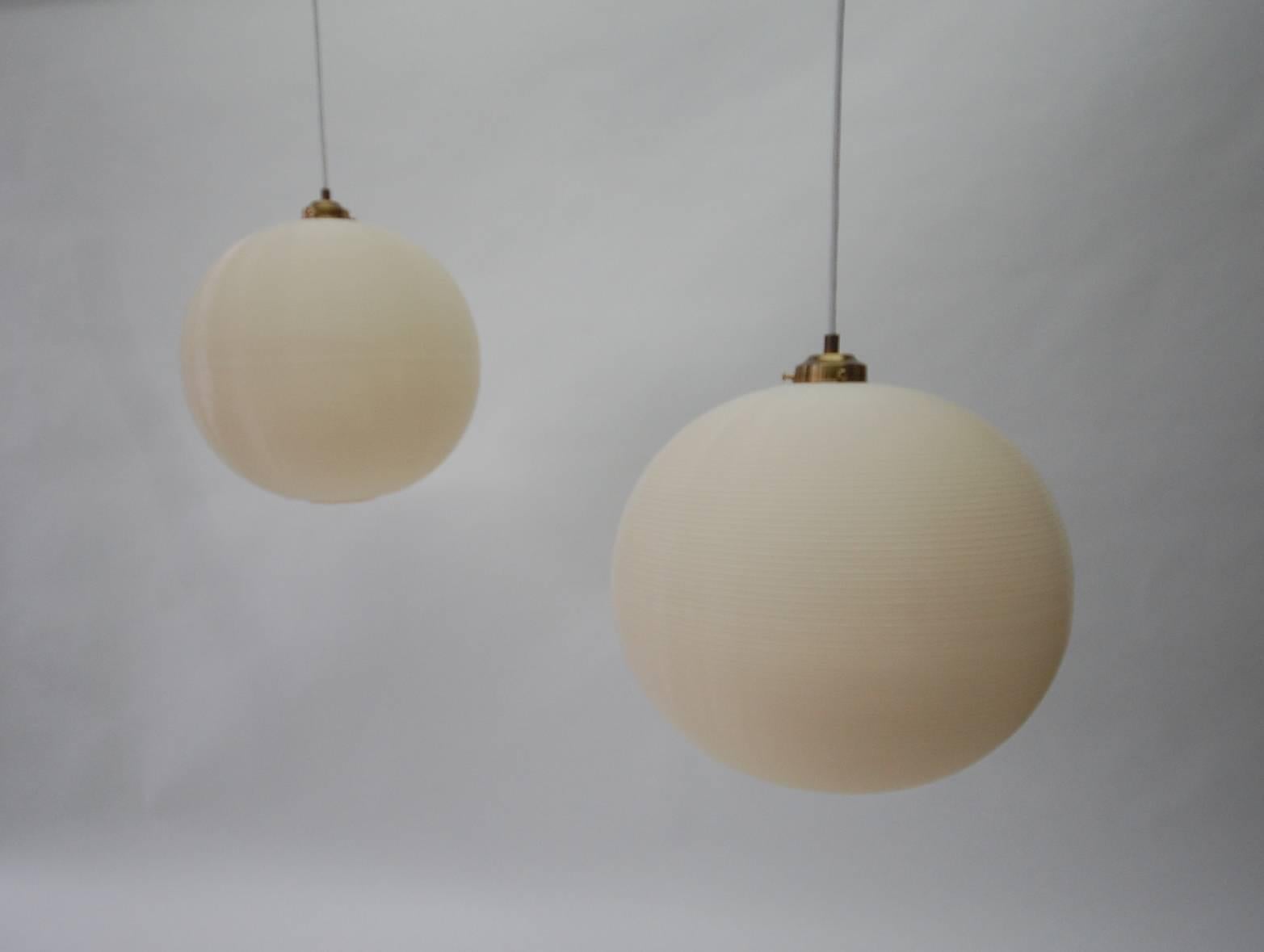Pair of Rotoflex pendant lights by Heifetz. Constructed of spun striated plastic in contrasting bands of white and off-white. Completely rewired. Brand new porcelain sockets, wiring and brass canopies. Priced for the pair, but will sell