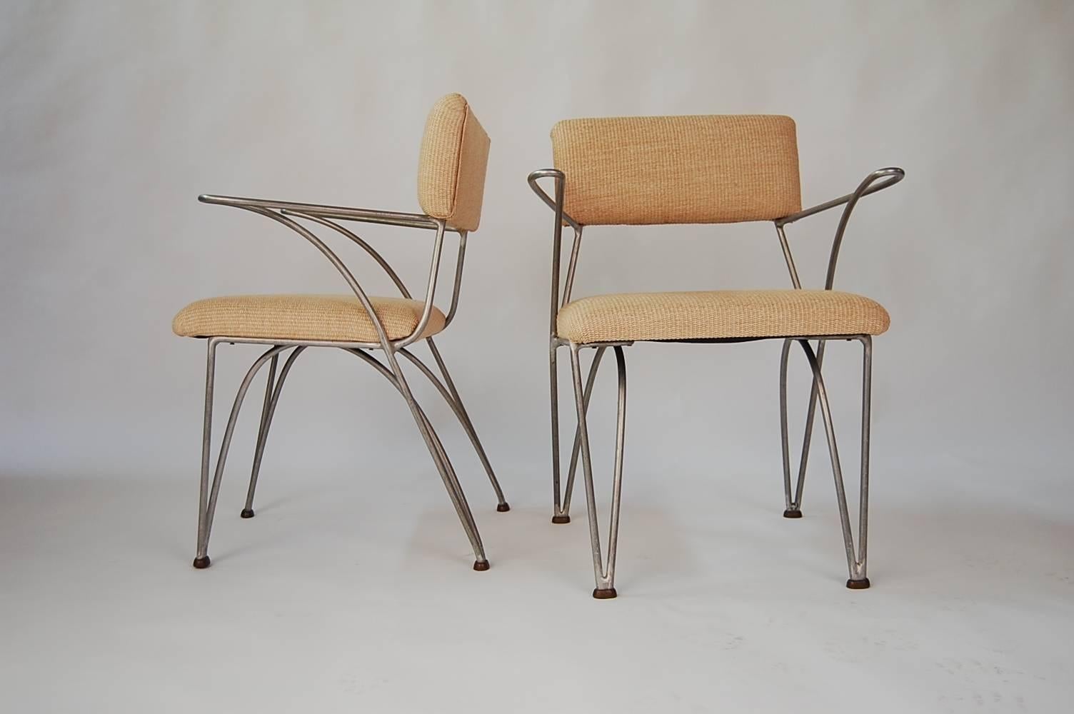 Pair of modernist chairs, circa 1950. We have been unable to document these chairs, but feel very strongly that they are an example early California modern design. They are constructed of solid, round rod aluminum, and have bronze feet. Upholstery