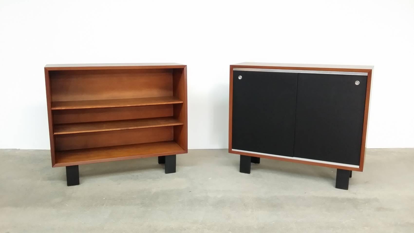 George Nelson Basic Cabinet series, designed circa 1946, and produced by Herman Miller. Cases are walnut, and have been professionally re-finished. One is open faced, and has tow adjustable shelves. The other has two sliding black lacquered masonite