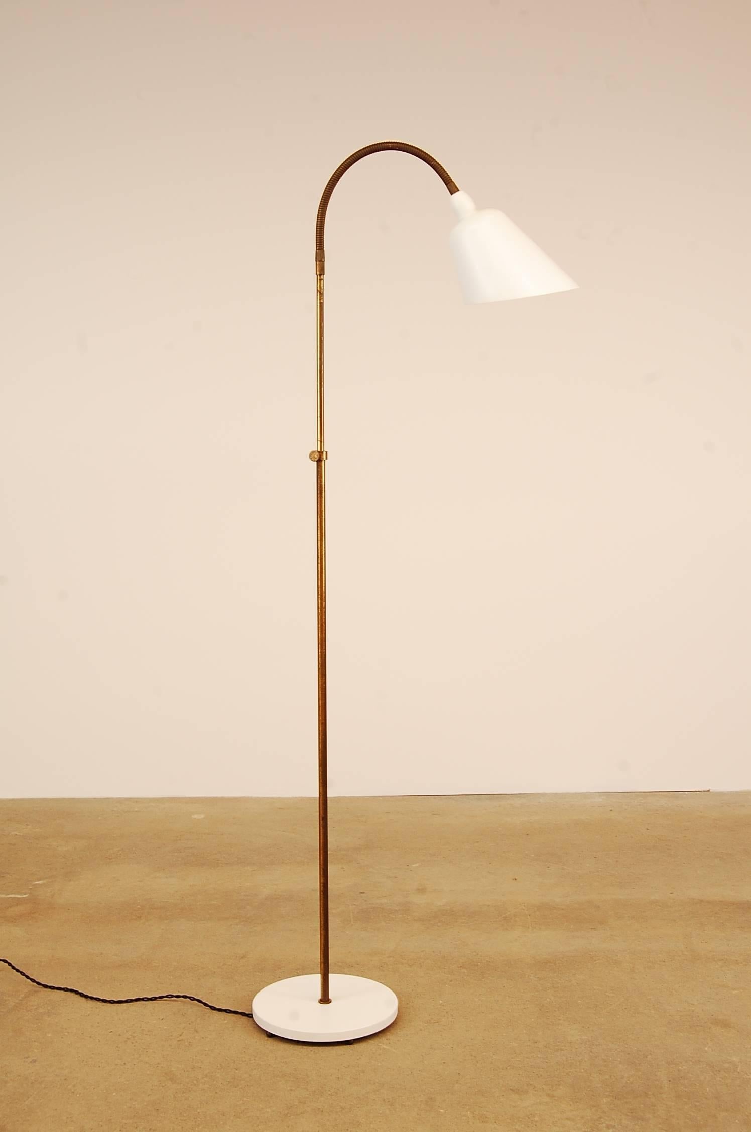 Arne Jacobsen floor lamp, designed circa 1929, and produced by Louis Poulsen in Denmark. Fully restored in a satin white lacquer, and completely rewired. The main shaft is solid brass, and is adjustable to heights roughly 49”-61