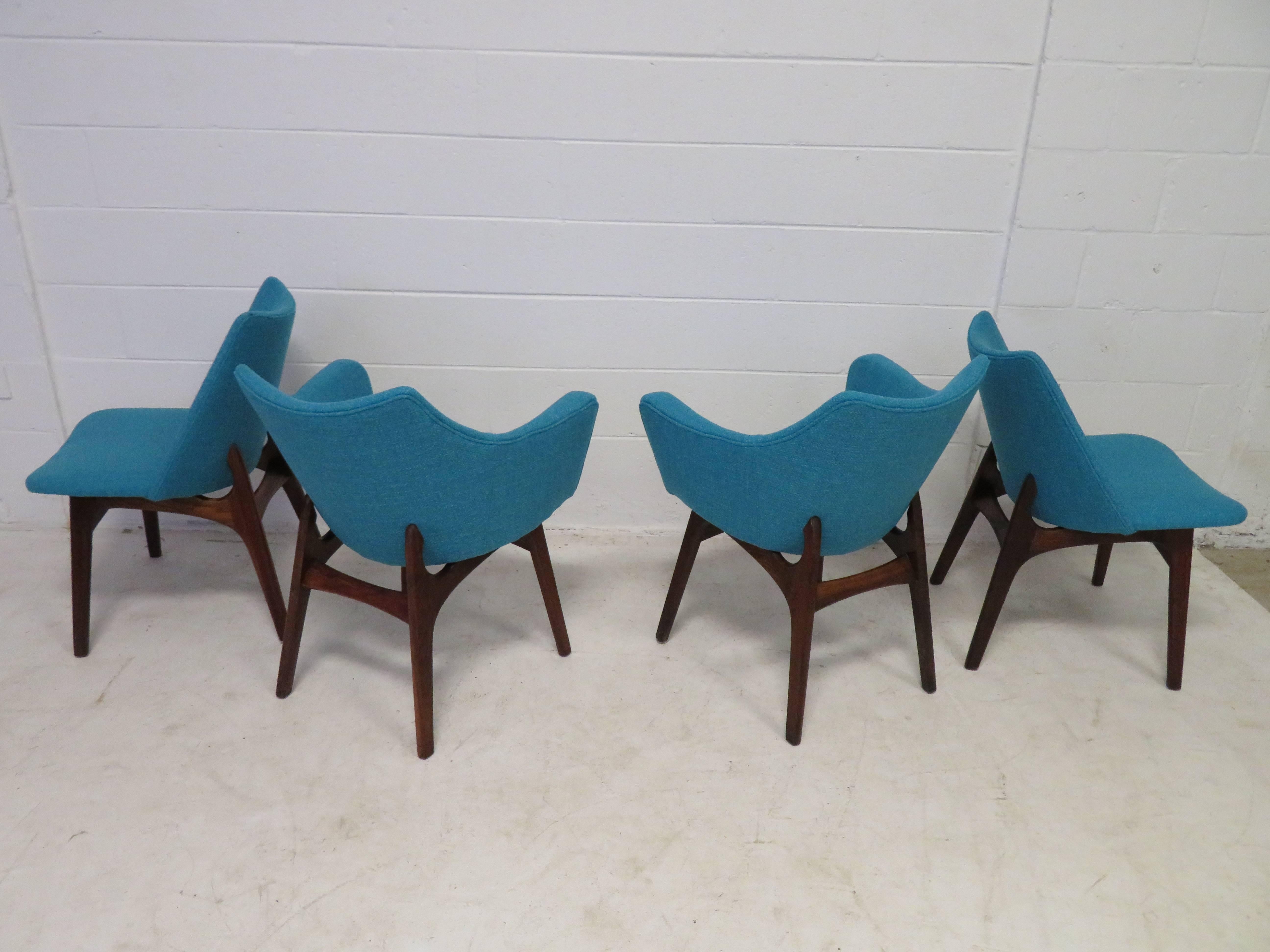 Fabulous set of four Adrian Pearsall sculptural walnut dining chairs. The set consists of two armchairs and two side chairs. They have been reupholstered in a wonderful period appropriate nubby woven fabric in a cool turquoise. We have many Adrian