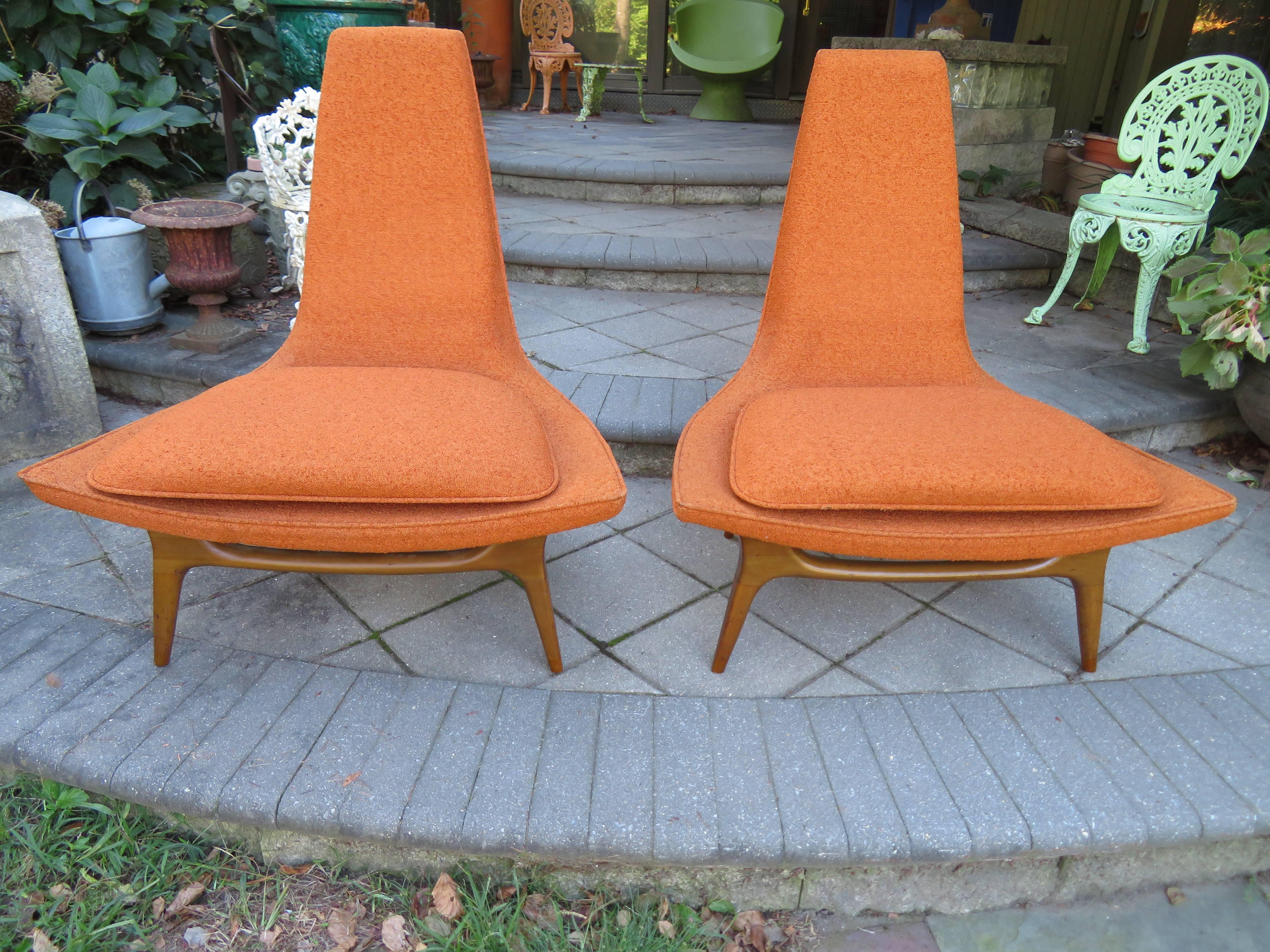 Sculptural pair of lounge chairs by Karpen, circa early 1950s. These lovely examples have subtly curved seats and tall tapered backs with beautifully formed light walnut stained legs. This pair retain their original fabric in lovely condition-a few