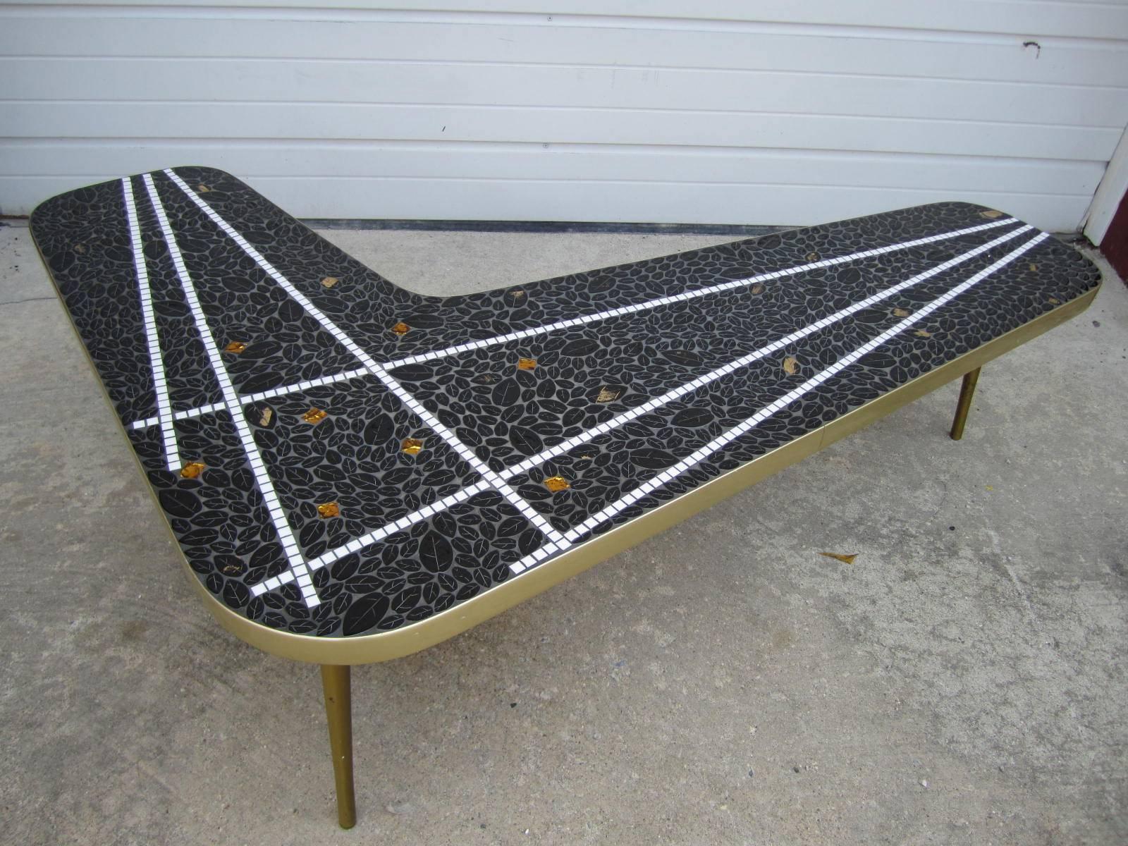 Gorgeous boomerang tile top mosaic coffee table. We love the black leaf shaped tiles mixed with the white radiating stripes and flecks of gold through-out.