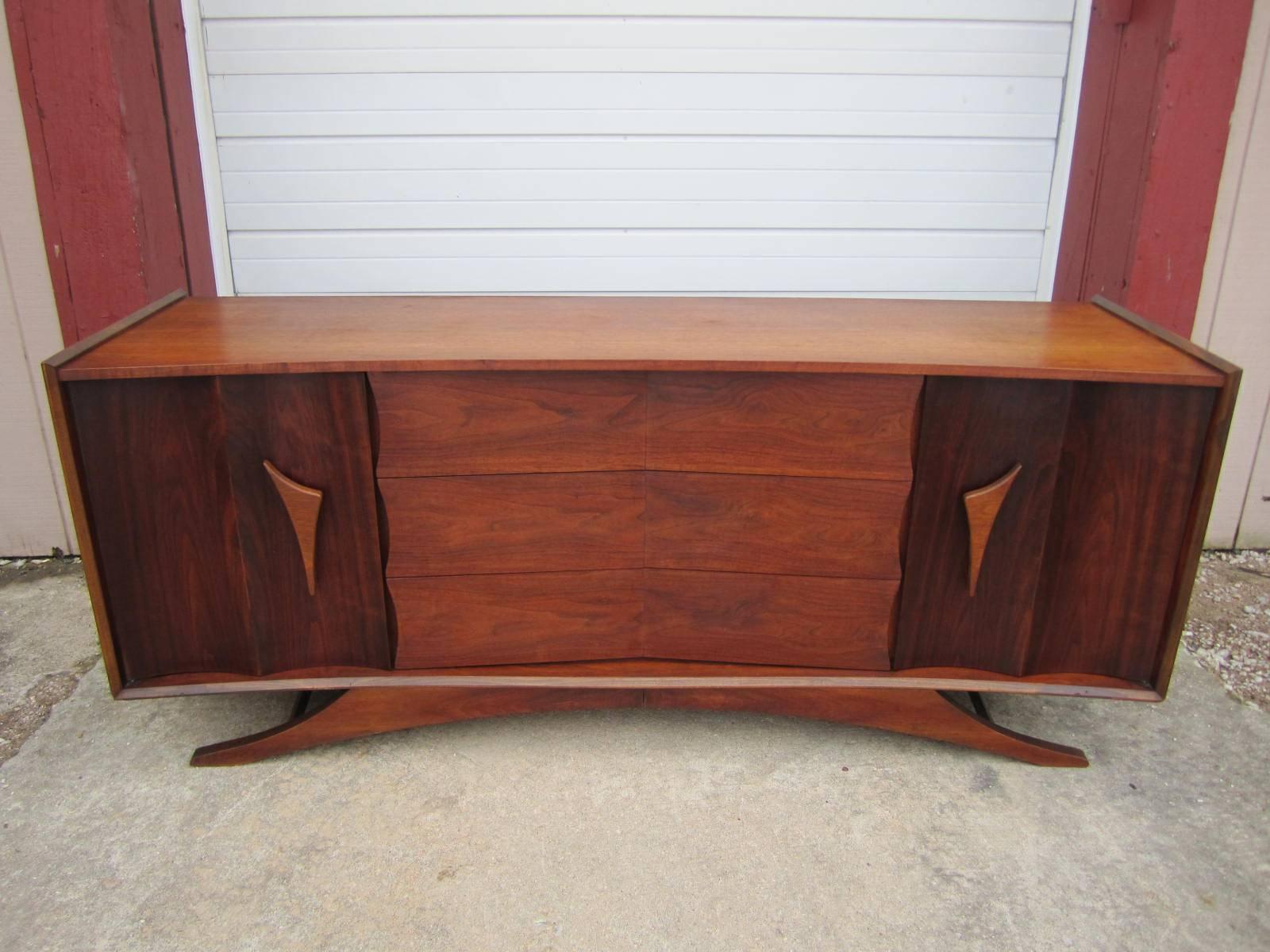 Fabulous bowed front sculptural walnut credenza. This gorgeous piece has beautifully carved double curved doors that open to reveal and nice bank of drawers on either side. Just look at the three large drawers in the middle how neat they are