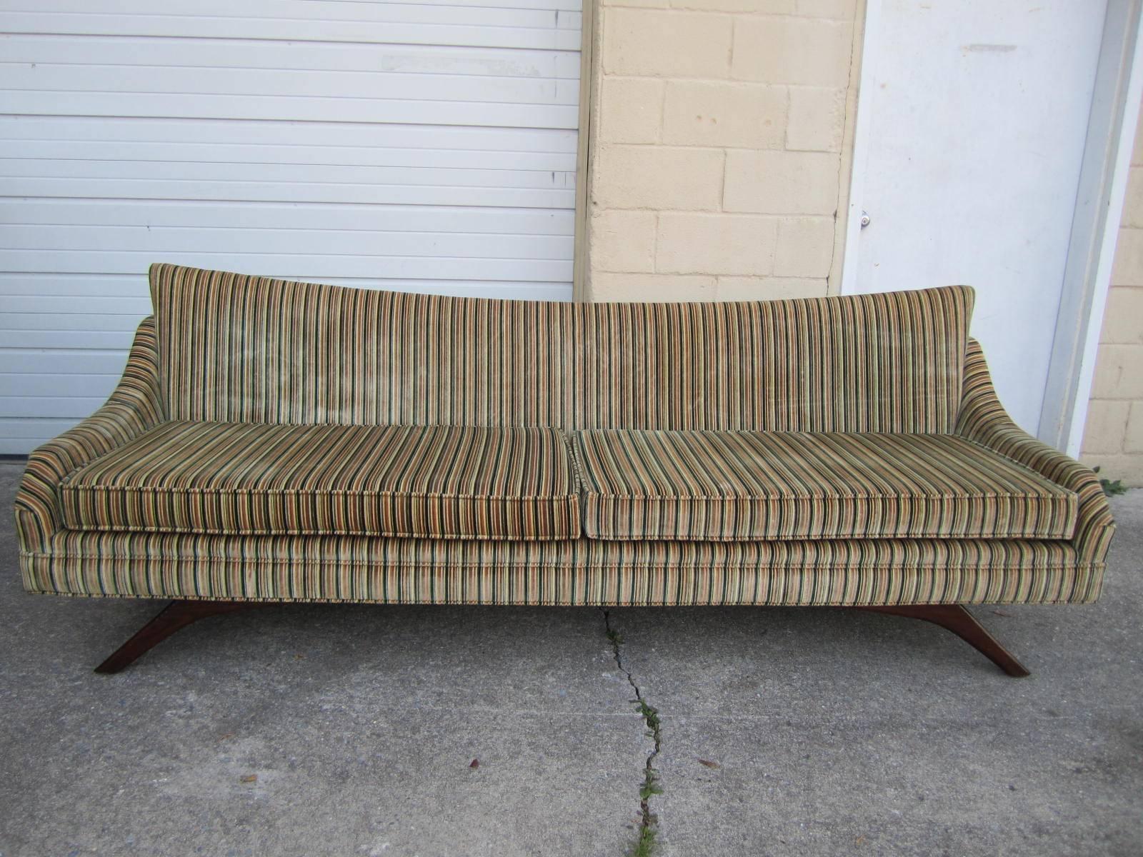Wonderful sofa with magnificent splayed walnut legs. We love everything about this sofa from its winged back and swooped arms to its original striped velvet upholstery. Just look at it from the back-just stunning. This is one of those amazing pieces