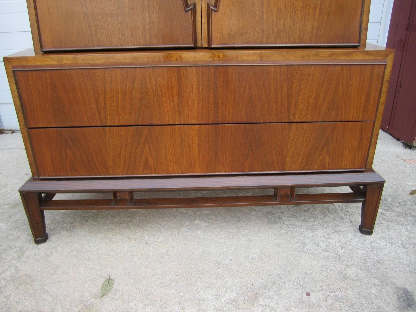 Lovely Hobey Helen tall walnut dresser chest. We love the interesting pierced hardware and the stylish well constructed base. This is a rare and collectible piece by New York socialites and furniture designers, Hobey and Helen Baker. Their pieces