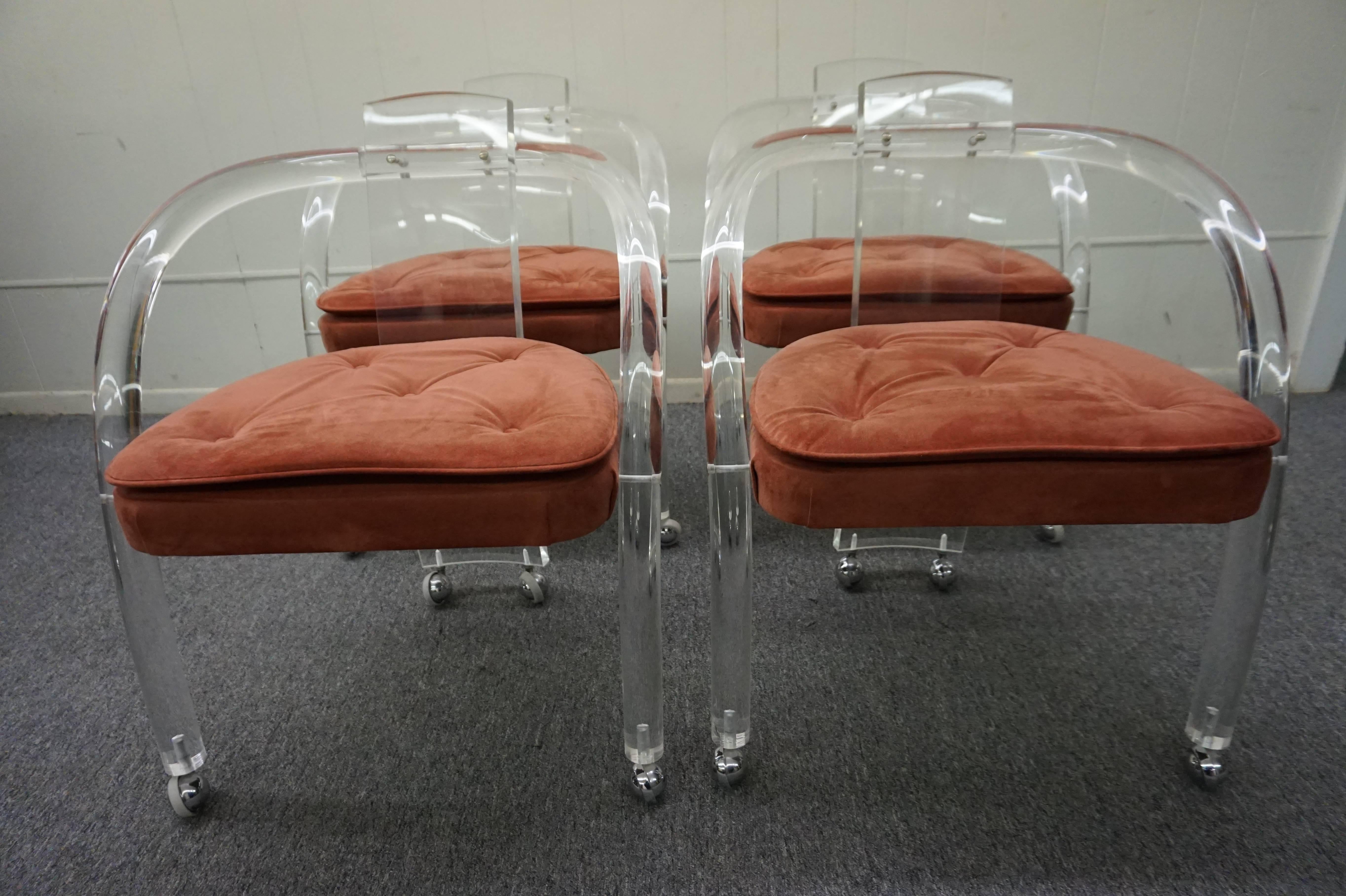 This set of four is an example of Charles Hollis Jones inspiration on other designs.  The set has four Lucite and dusty rose ultra suede cushioned chairs on casters.

By Wycombe-Meyer (NY), this is their 'Loop' chair c.1975