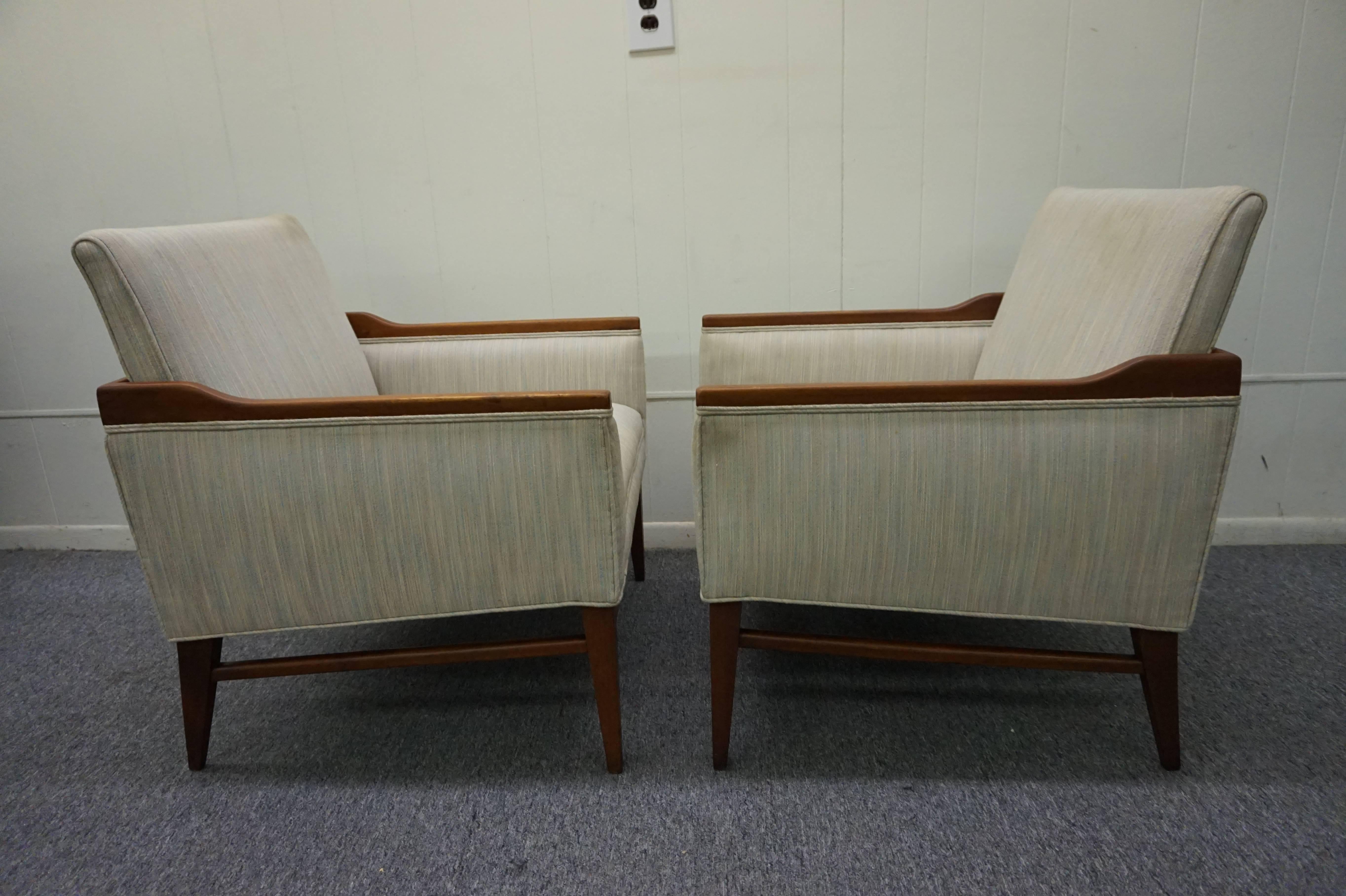 Stunning pair of American mid-century modern walnut lounge chairs.  Unusual walnut details surround the the top edge and looks quite smart.  