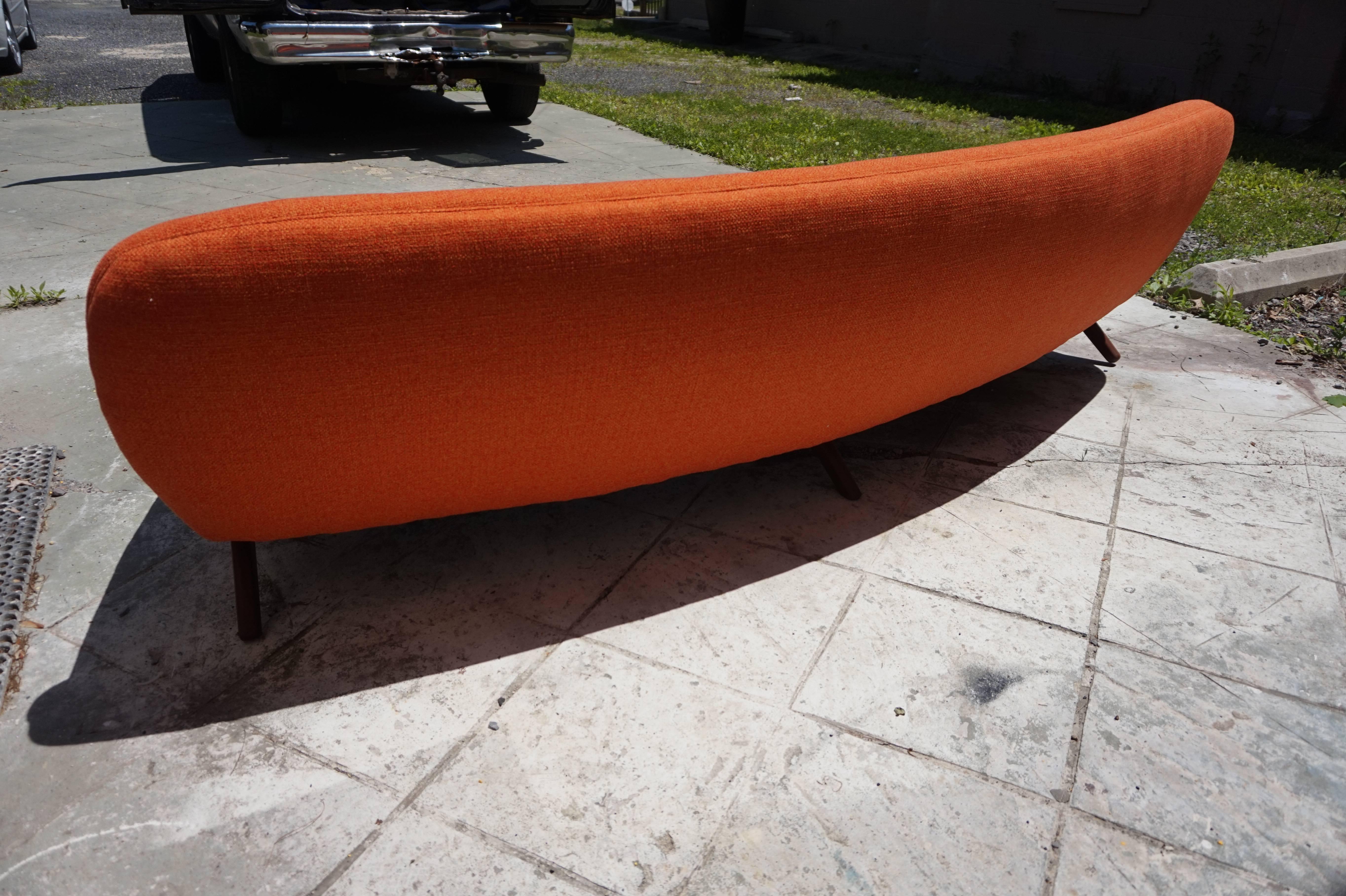 Outstanding Danish Modern Leif Hansen style curved sofa with amazing walnut legs. This sofa is in fantastic condition with brand new Sunset orange woven fabric-just gorgeous! All new foam and straps-this sofa is ready to slip right in your swanky