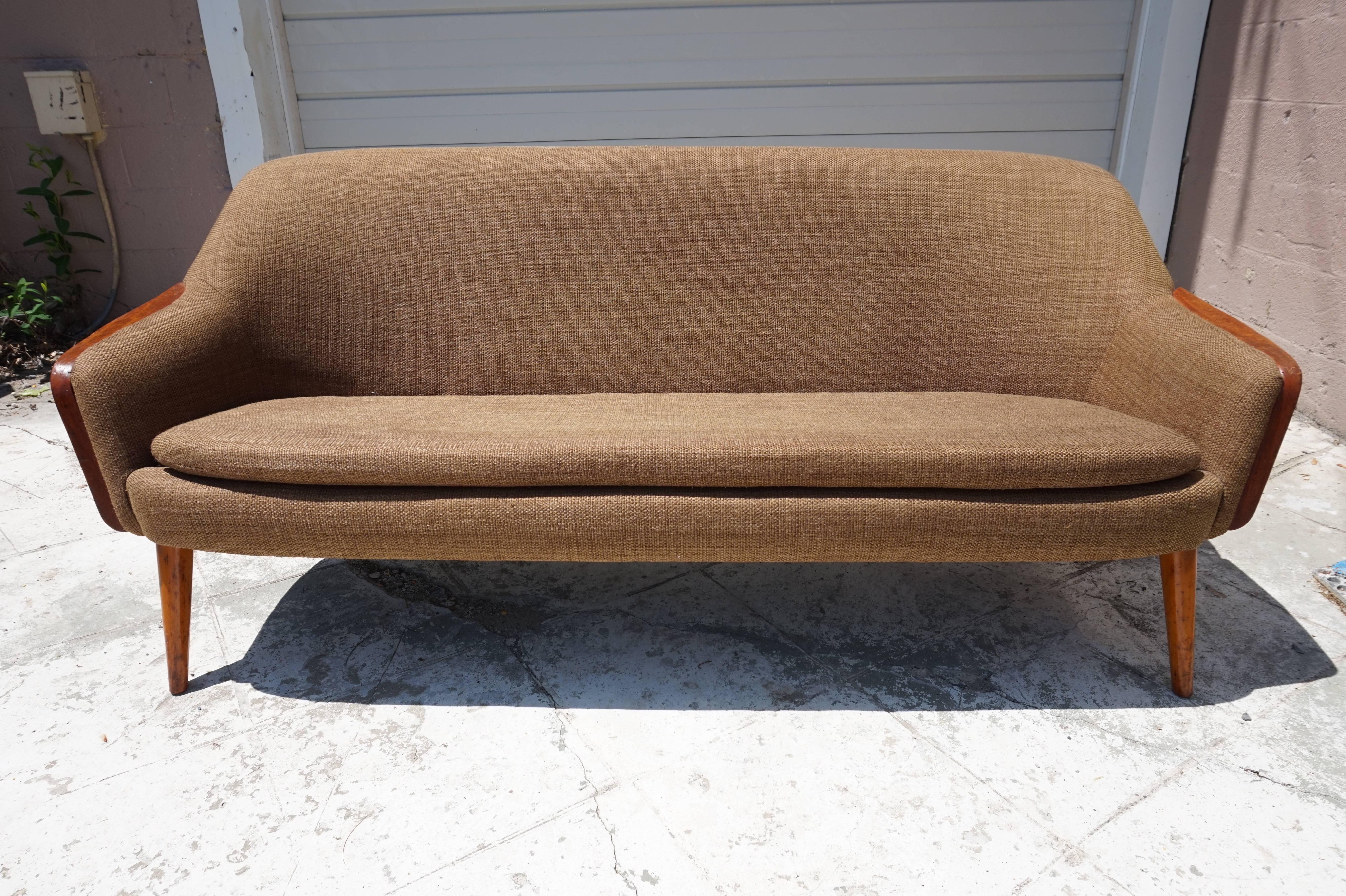 Handsome Nanna Ditzel style teak arm loveseat sofa. Great for a small apartment or special nook, this small sofa or loveseat packs a lot of Danish punch and surprisingly comfortable.