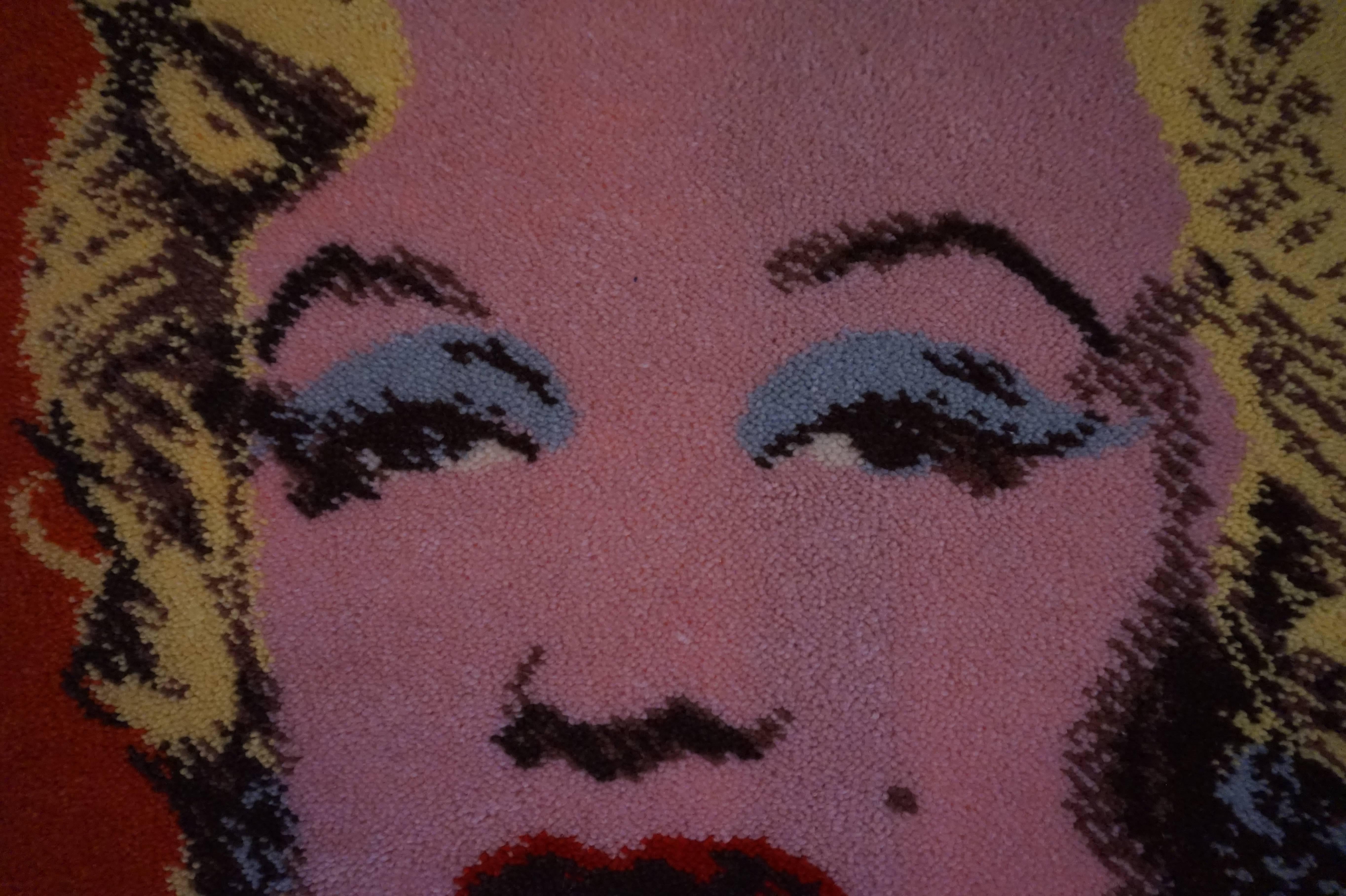 Ege Art rug designed in the style of Andy Warhol depicts his famous Marilyn Monroe imagery.  Warhol is one of the most important and celebrated American artists of the 20th century. This rug was used as a wall hanging and still retains its wooden