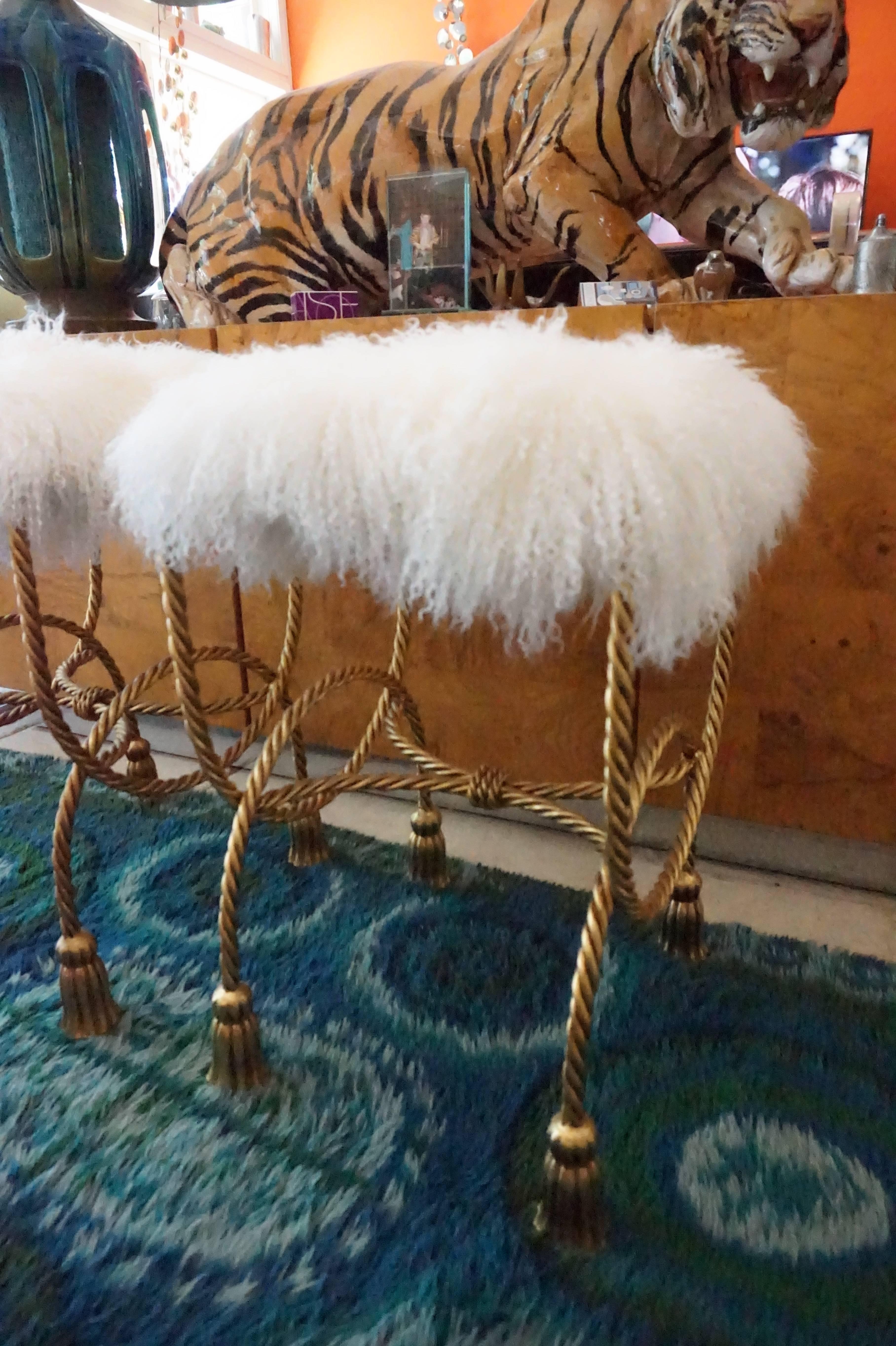 Stunning pair of vintage gilded rope and tassel stools with new Mongolian lamb seat pads.