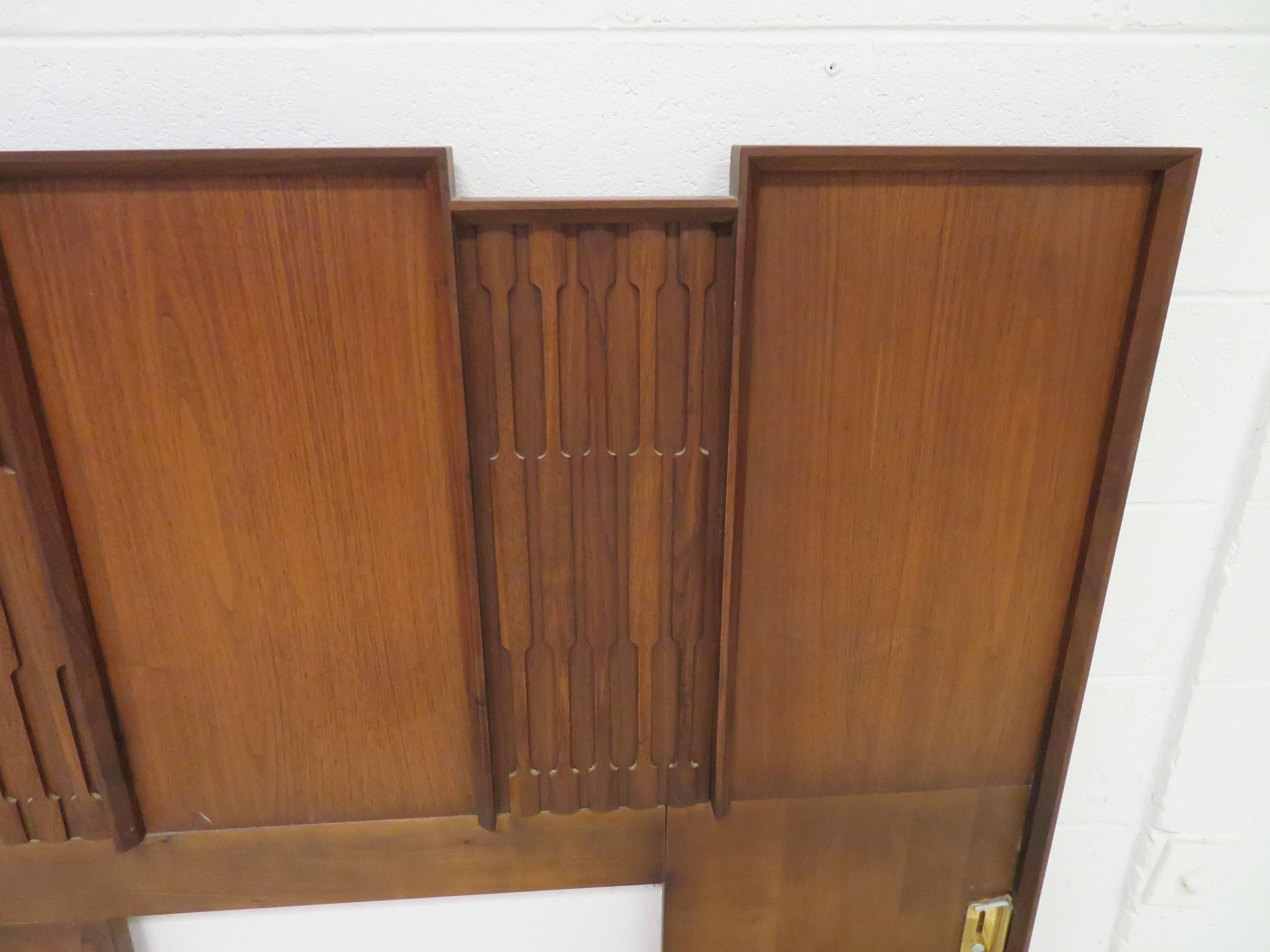 Wonderful sculptural walnut brutalist king-size headboard. We love the contrast of the carved brutalist panels along with the taller smooth panels.