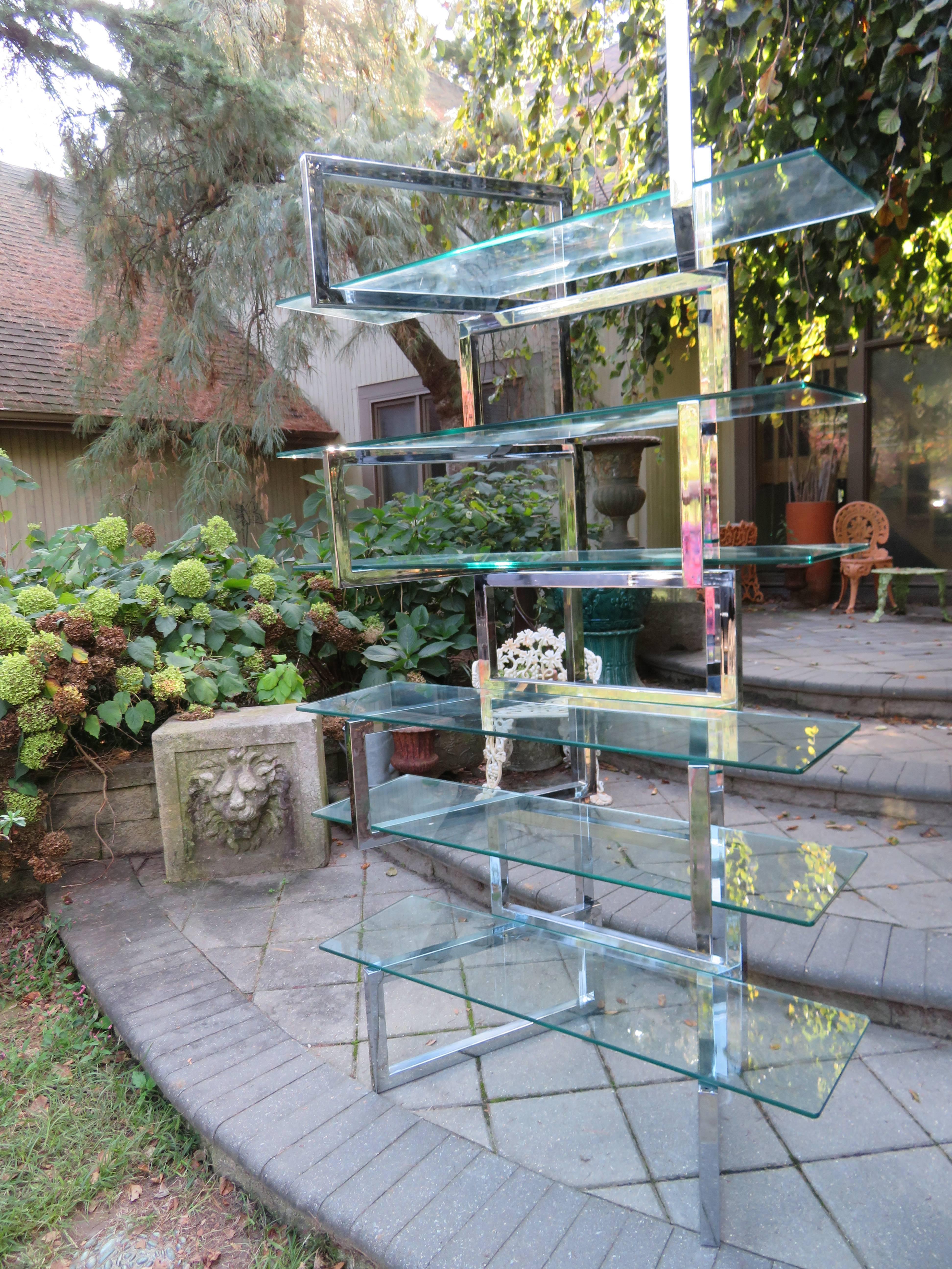 Over the top Milo Baughman chrome and glass etagere. The chrome-plated steel heavy square tubes are hinged to allow for the units panels to pivot. The chrome is very nice with only minor signs of wear. The glass shelves can be arranged in different