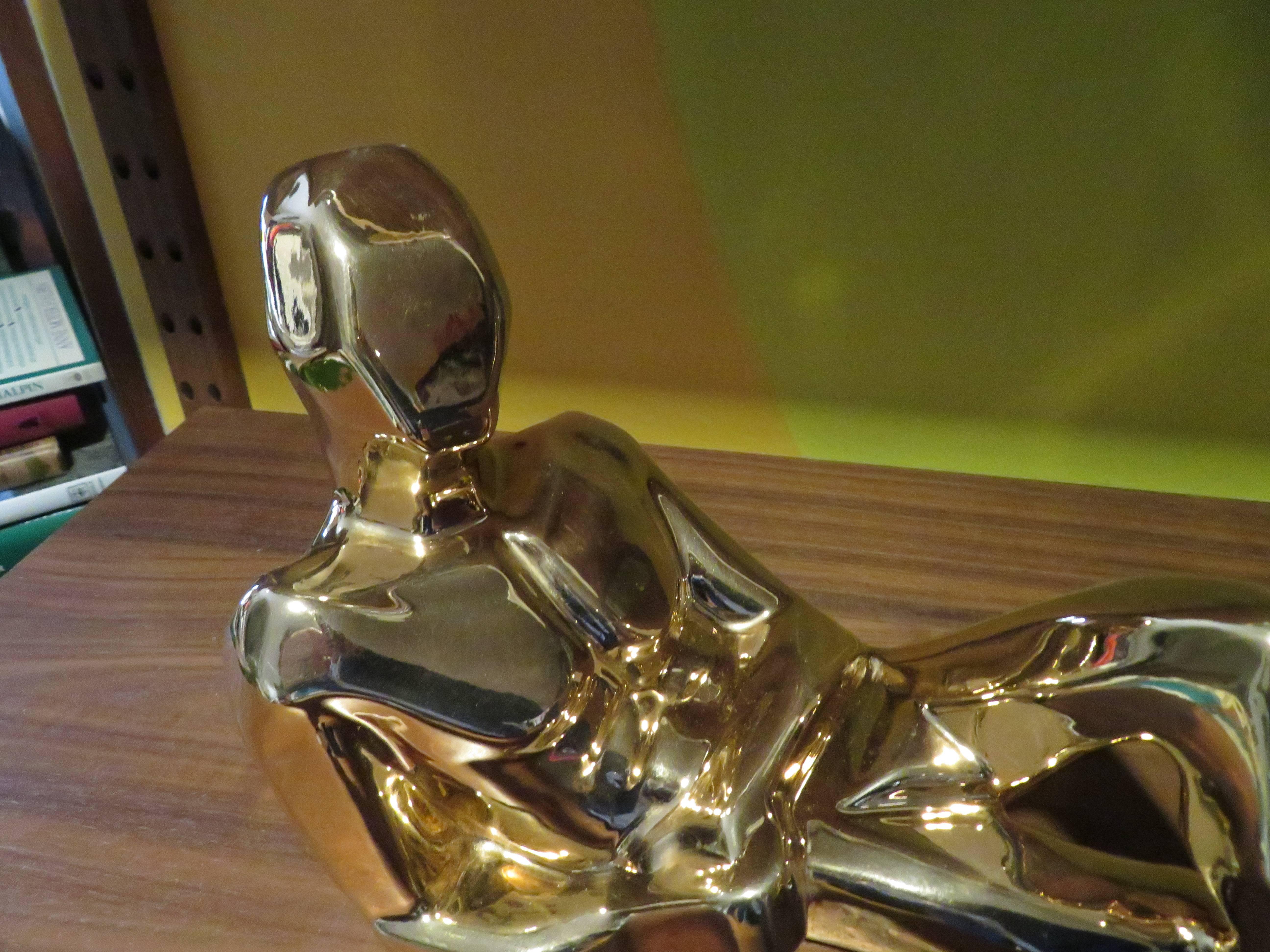 A chic Mid-Century Modernist figurative sculpture in plated gold by Jaru of California. This example depicts a reclining man in repose. The artist's nod to Cubism is apparent here as is a very slick, modern style. A lovely sculpture for any space.