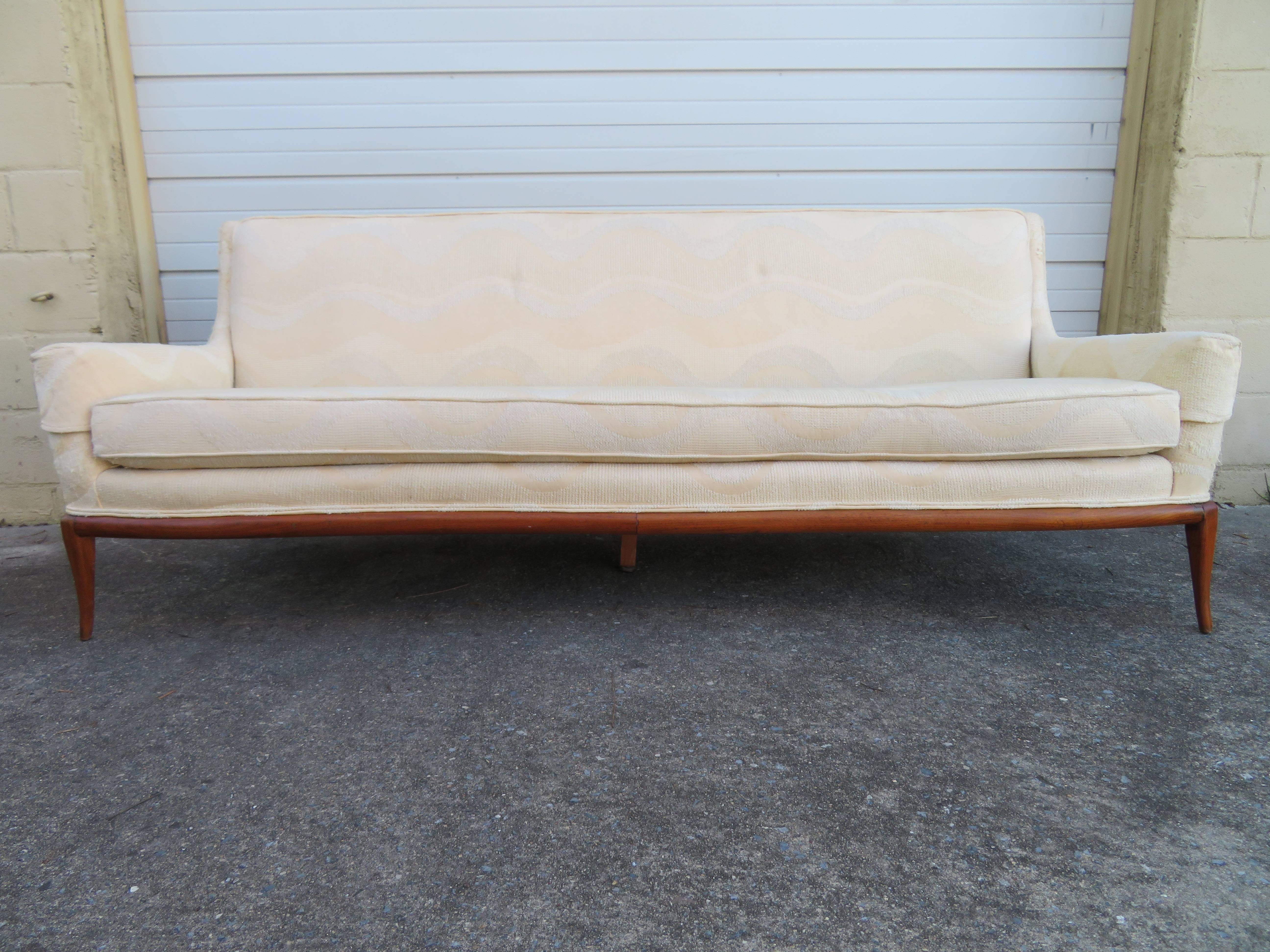 Lovely Robsjohn-Gibbings attributed walnut sofa with sexy flared feet and double bowed front bottom edge. Yes, this piece will need to be reupholstered but that's what you designers are looking for anyway-right?.