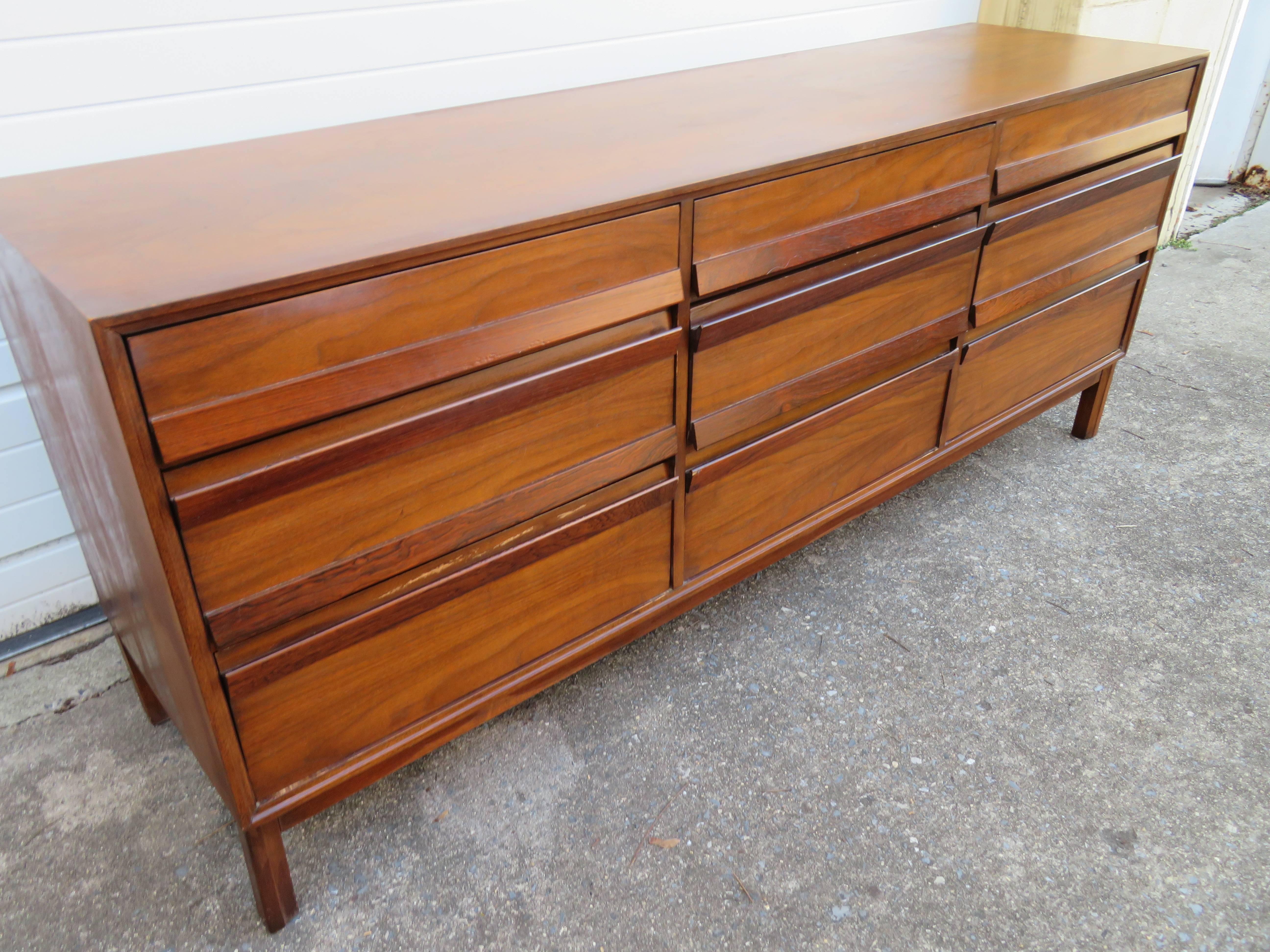Handsome American of Martinsville walnut and rosewood credenza. With simple clean lines this piece has rosewood pulls and a walnut case. Please check out the other matching pieces to this collection in our other 1stdibs offerings including headboard