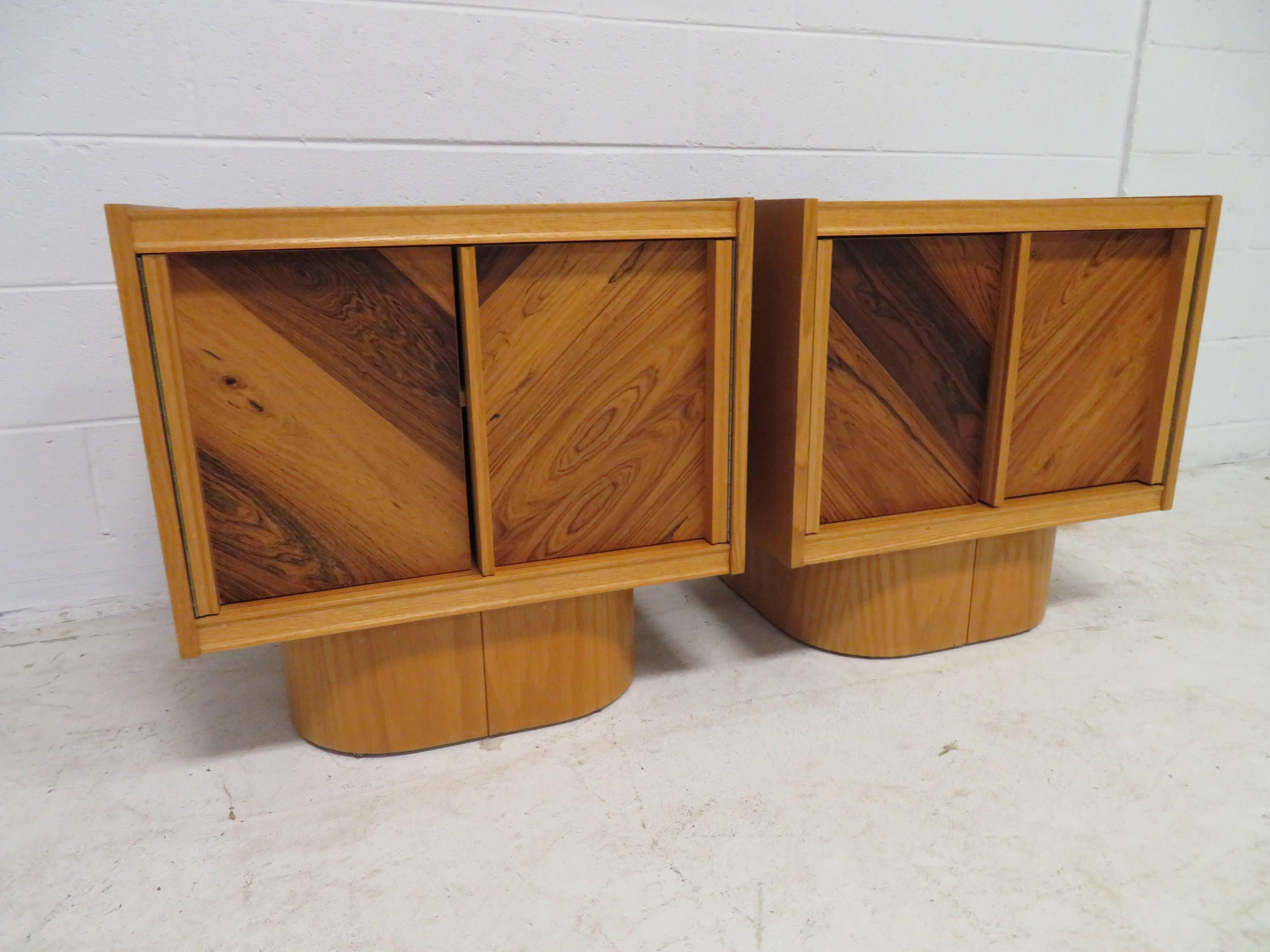 Unusual plinth base Mid-Century Modern nightstands. We love the contrast of the light and dark wood on the door fronts which open to reveal a single shelf in each. We do have the original queen-size headboard available in another of our 1stdibs