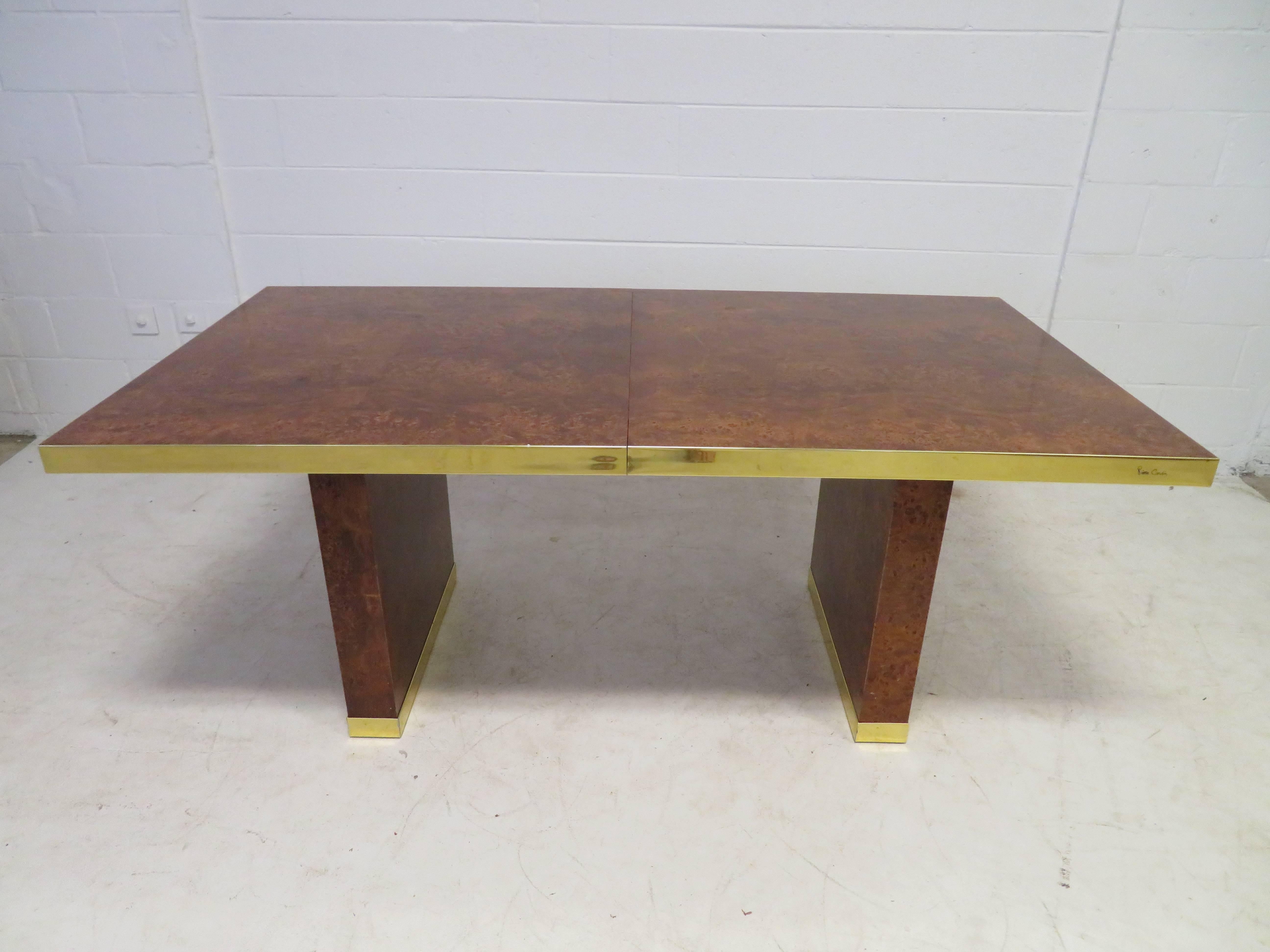 Handsome burl and brass dining table by Pierre Cardin, circa 1970s. Bookmatched olive wood with lovey brass detail. Pure sophistication! Very nice vintage condition, brass with wonderful patina. This table retains its original finish and has two